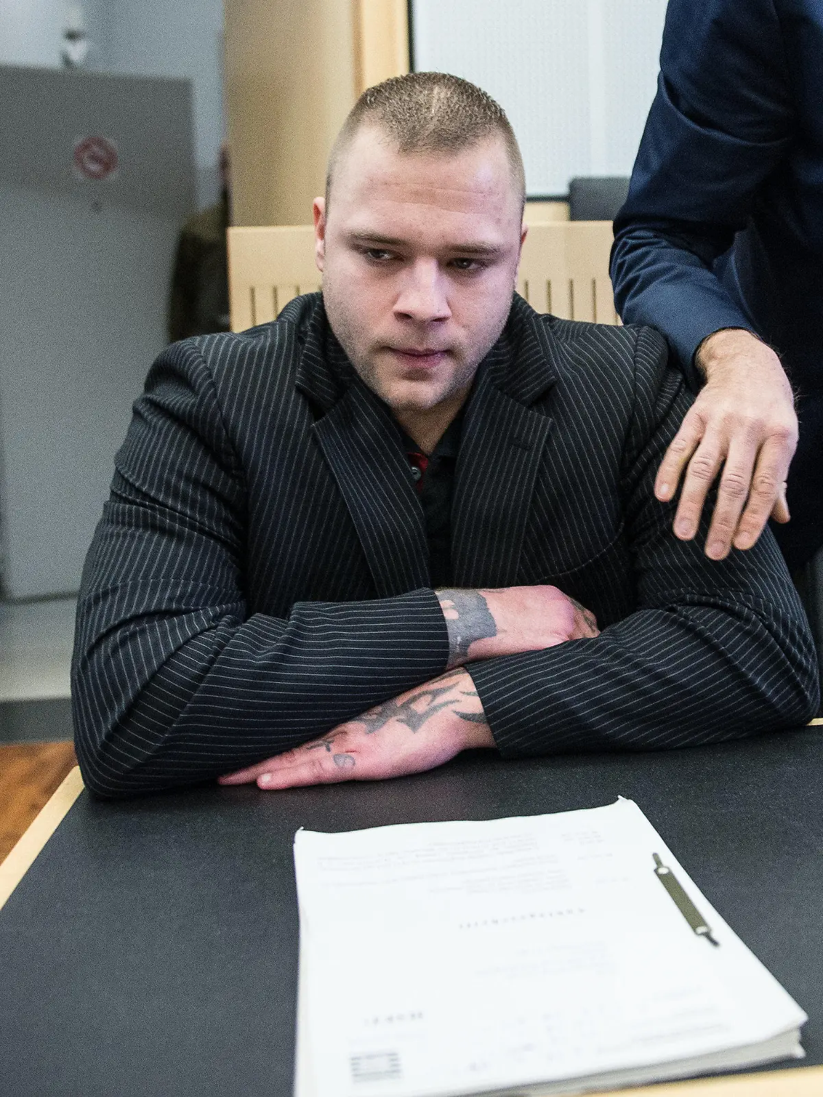 Der Angeklagte Patrick S. sitzt vor der Urteilsverkündung am 12.12.2016 in Limburg (Hessen) im Gerichtssaal und schaut einen Pressevertreter an. Der Verteidiger legt seine Hand auf die Schulter des Angeklagten. Weil er einen Polizisten an Heiligabend 2015 erstochen und dessen Kollegen schwer verletzt hat, muss der 28-Jährige lebenslang in Haft. Das Landgericht Limburg verurteilte den Mann am Montag unter anderem wegen Mordes und versuchten Mordes. Foto: Andreas Arnold/dpa +++(c) dpa - Bildfunk+++