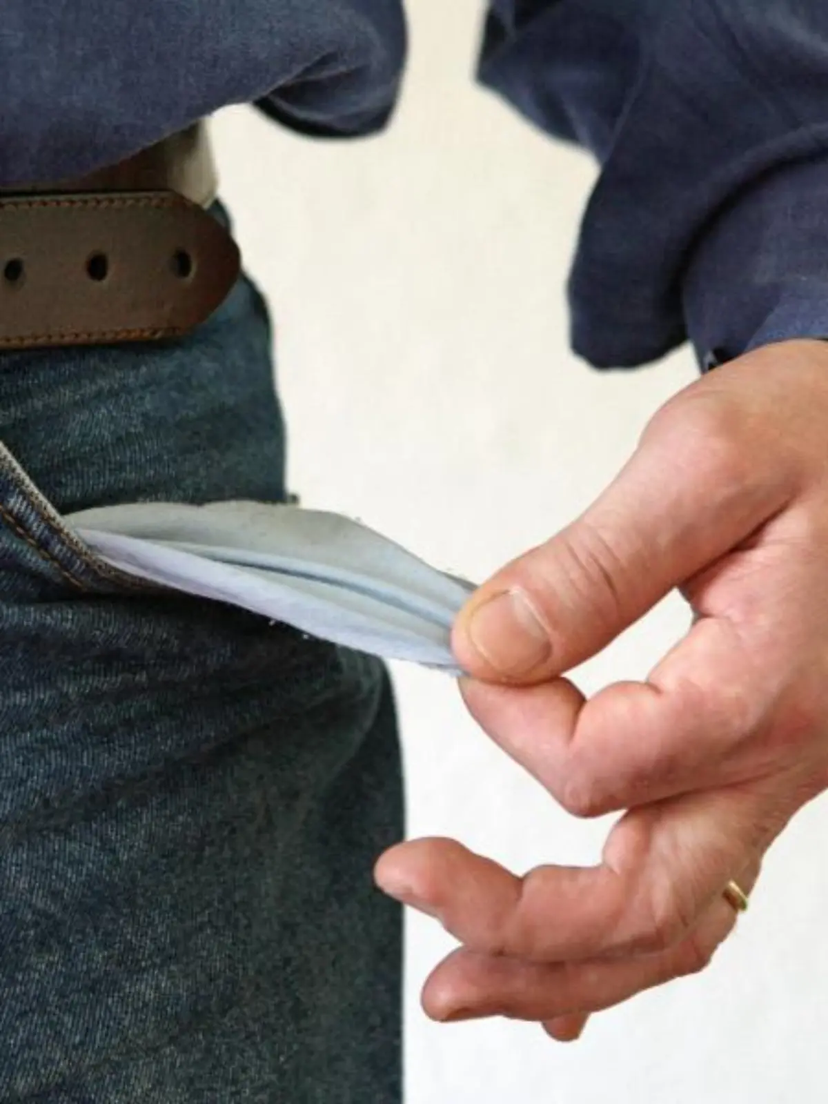 Mann zeigt seine leere Hosentasche