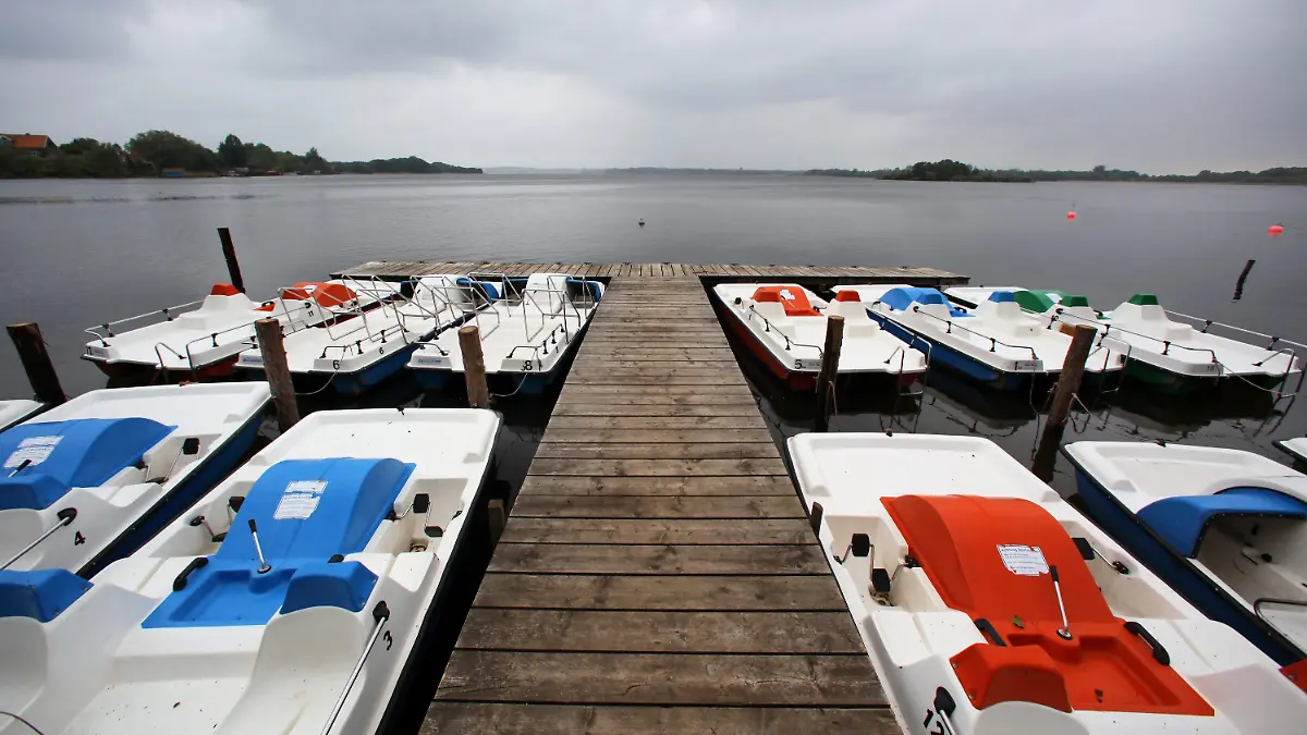Tretboote liegen am Montag (07.06.2010) im Regen an einem Anlegesteg am Schaalsee in Zarrentin (Ludwigslust). Mit Regen und Temperaturen knapp über zehn Grad zeigt sich das Wetter zu Wochenbeginn in Norddeutschland von seiner unfreundlichen Seite. Für die zweite Wochenhälfte erwarten die Meteorologen jedoch wieder Sommerwetter mit Temperaturen bis zu 30 Grad. Foto: Jens Büttner dpa/lmv  +++(c) dpa - Bildfunk+++