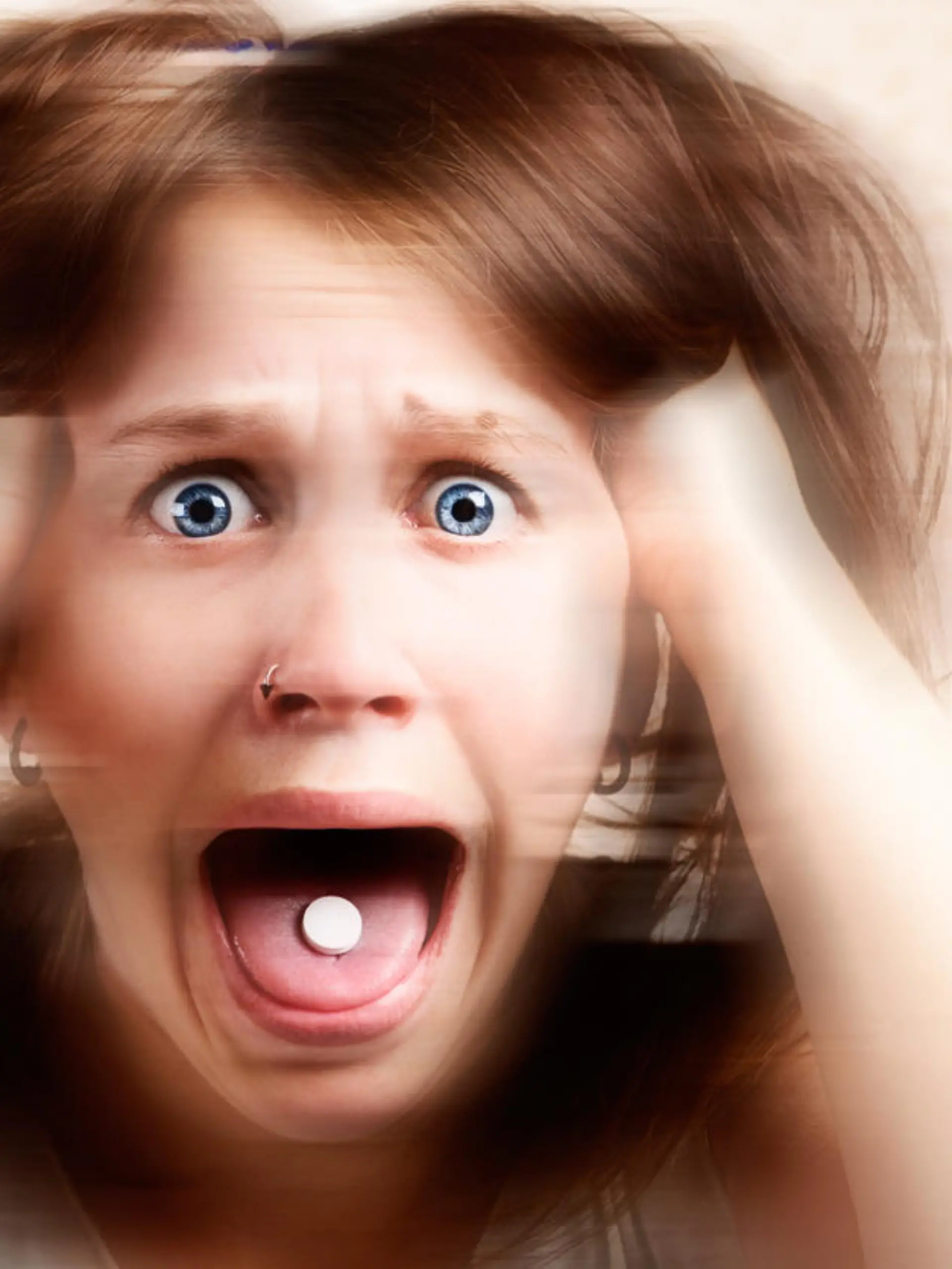 A distorted portrait of a terrified young woman with a pill in her mouth, screaming and tearing her hair out.  Symbolizes the horrific results of drug abuse. 