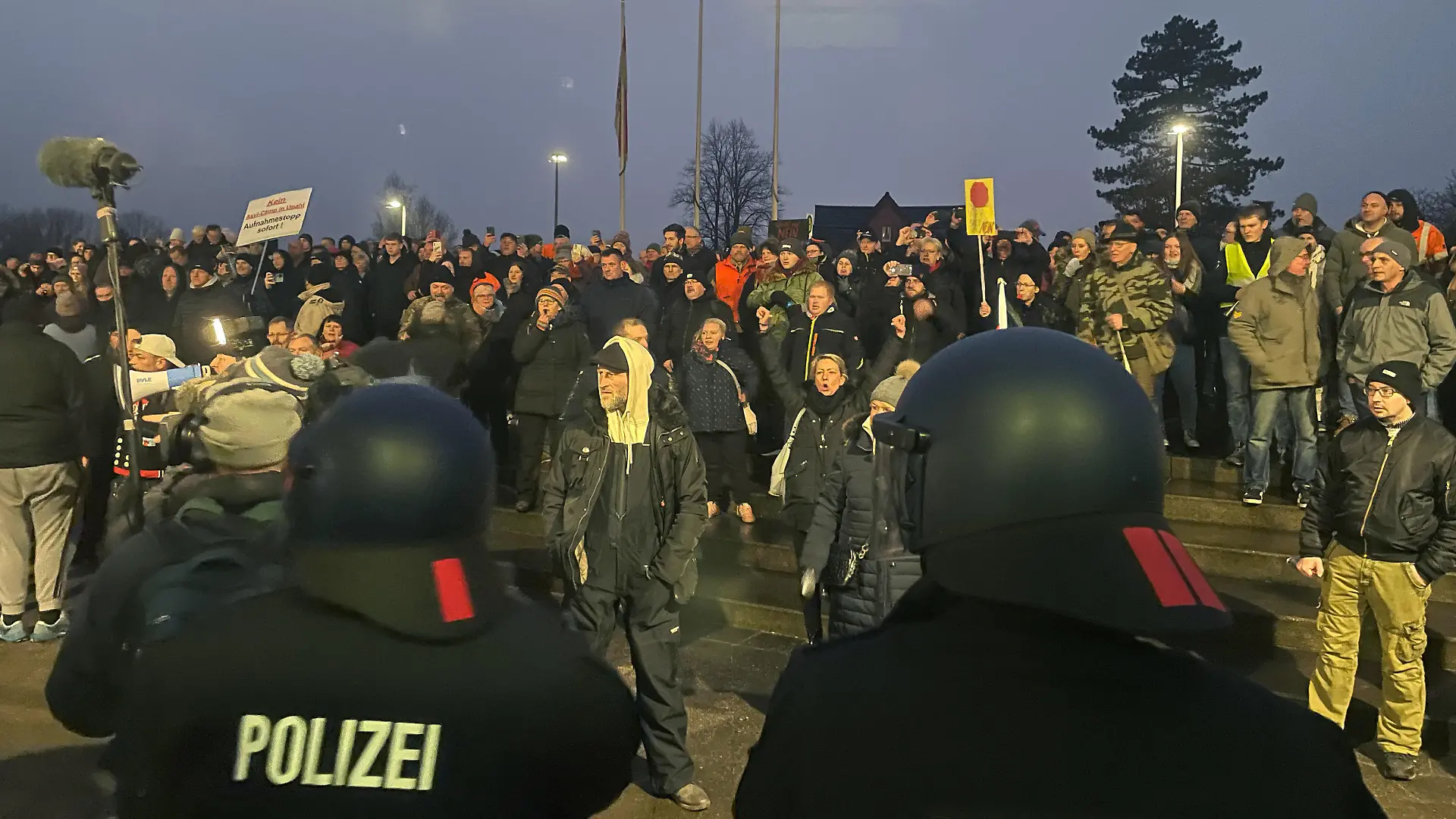 26.01.2023, Mecklenburg-Vorpommern, Grevesmühlen: Polizisten sind bei einer Versammlung vor dem Sitzungsgebäude des Kreistages im Einsatz. Bei einer Versammlung gegen die Einrichtung einer Flüchtlingsunterkunft in Mecklenburg-Vorpommern ist es in Grevesmühlen zu tumultartigen Szenen gekommen. Vor dem Sitzungsgebäude des Kreistages von Nordwestmecklenburg kamen nach Polizeiangaben am Donnerstag 700 Menschen zusammen. Einige Teilnehmer der angemeldeten Versammlung hätten versucht, sich Zutritt zum Landkreisgebäude zu verschaffen, seien aber von der Polizei daran gehindert und zurückgedrängt worden. Foto: Malte Behnk/Ostsee-Zeitung /dpa +++ dpa-Bildfunk +++