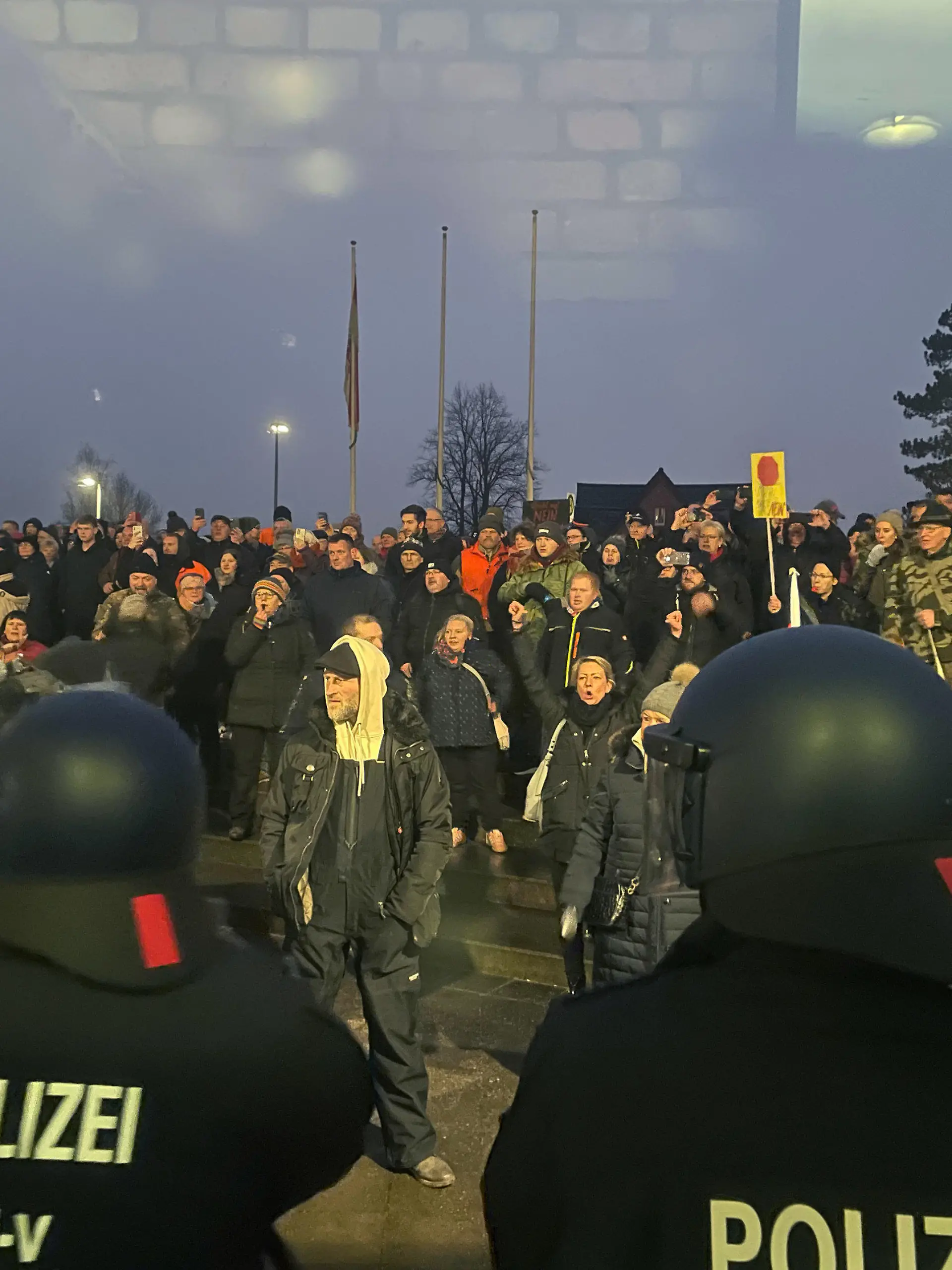 26.01.2023, Mecklenburg-Vorpommern, Grevesmühlen: Polizisten sind bei einer Versammlung vor dem Sitzungsgebäude des Kreistages im Einsatz. Bei einer Versammlung gegen die Einrichtung einer Flüchtlingsunterkunft in Mecklenburg-Vorpommern ist es in Grevesmühlen zu tumultartigen Szenen gekommen. Vor dem Sitzungsgebäude des Kreistages von Nordwestmecklenburg kamen nach Polizeiangaben am Donnerstag 700 Menschen zusammen. Einige Teilnehmer der angemeldeten Versammlung hätten versucht, sich Zutritt zum Landkreisgebäude zu verschaffen, seien aber von der Polizei daran gehindert und zurückgedrängt worden. Foto: Malte Behnk/Ostsee-Zeitung /dpa +++ dpa-Bildfunk +++