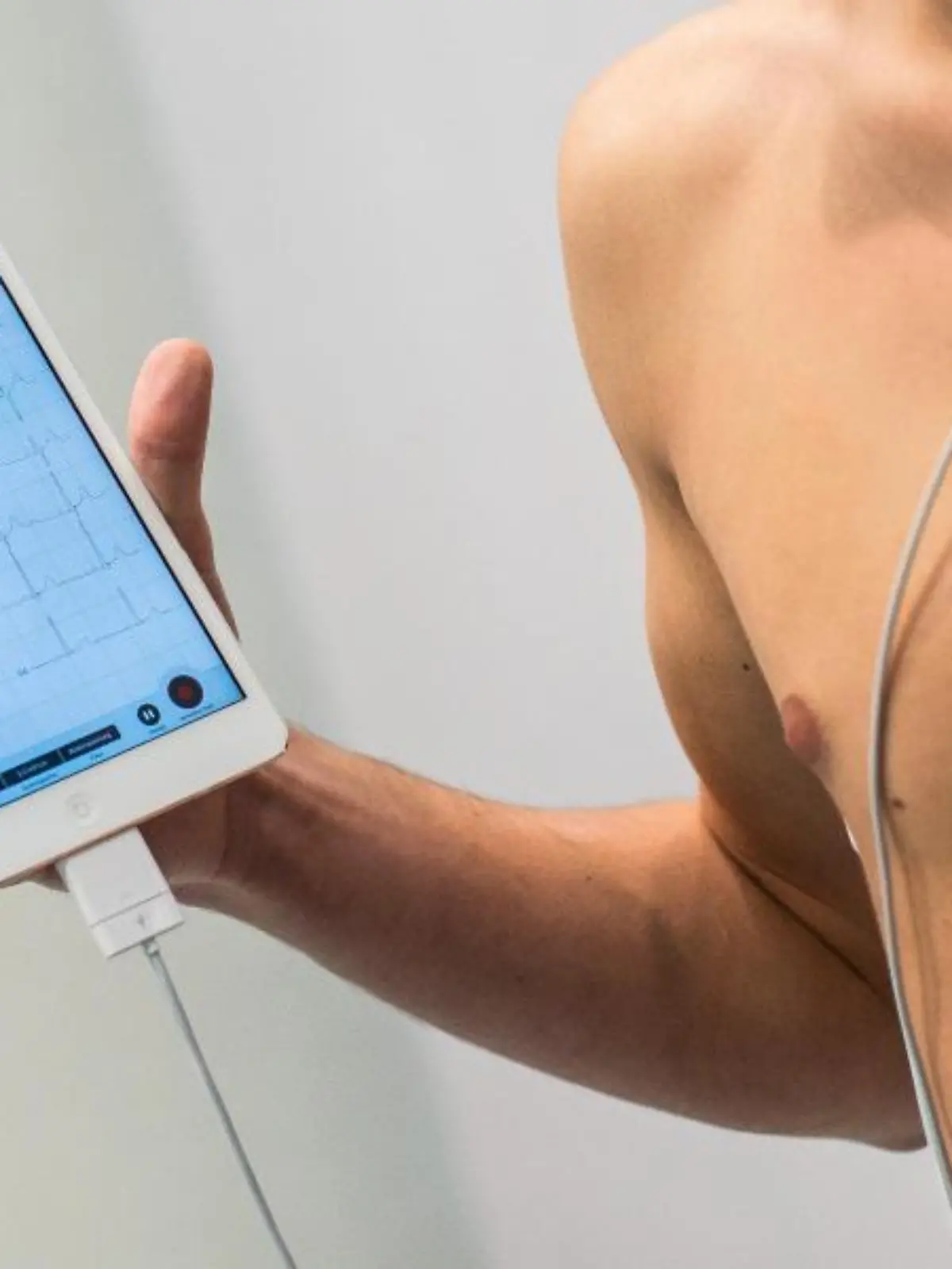 Ein Mann zeigt ein mobiles EKG-System