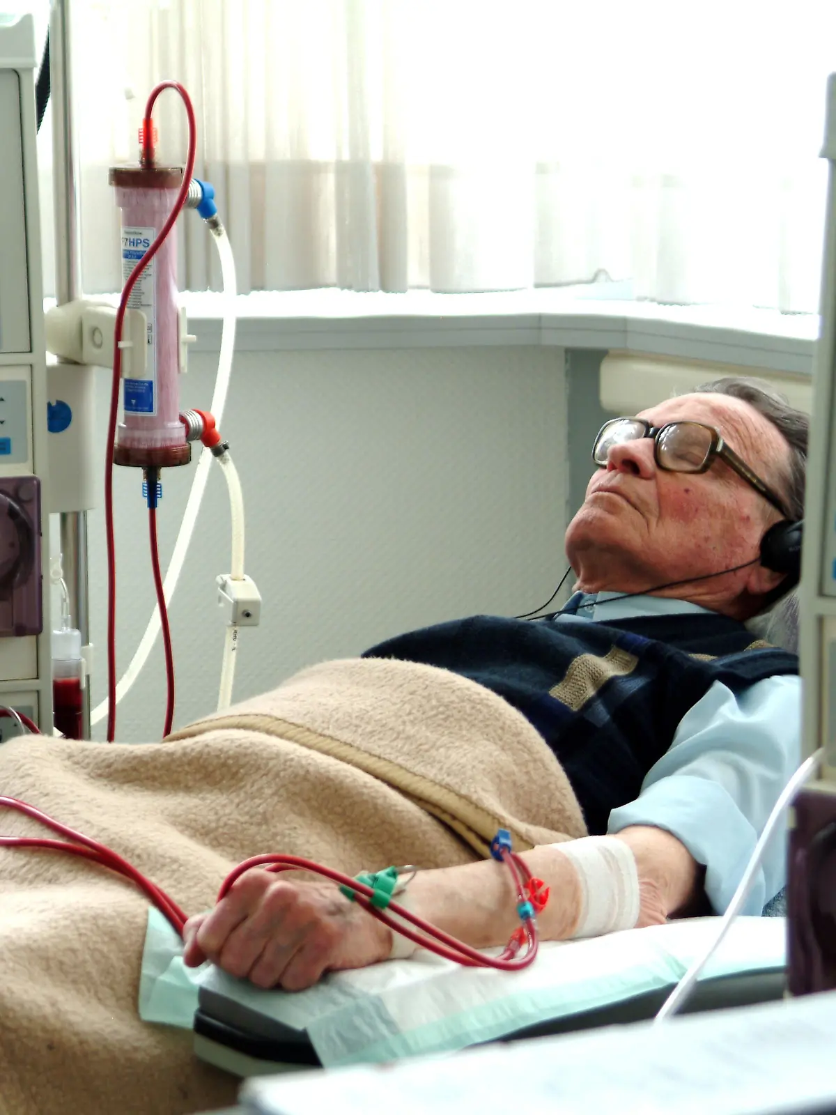Ein Patient mit Kopfhörern und geschlossenen Augen entspannt sich bei Musik während der Blutwäsche am Dialyse-Gerät. Aufgenommen am 22.03.2004 in einer Dialysepraxis in Iserlohn. Ein wesentlicher Teil ihres Lebens ist für Patienten, die an einer Niereninsuffizienz erkrankt sind, die Dialyse. Zwei bis dreimal in der Woche müssen sie sich für fünf Stunden einer Blutwäsche unterziehen, da ihre Nieren diese Funktion nicht mehr gewährleisten. Zuwendung von Arzt und Arzthelferinnen sowie dem Dialysekrankenpfleger sind da besonders wichtig. Foto: Klaus Rose +++(c) dpa - Report+++ | Verwendung weltweit