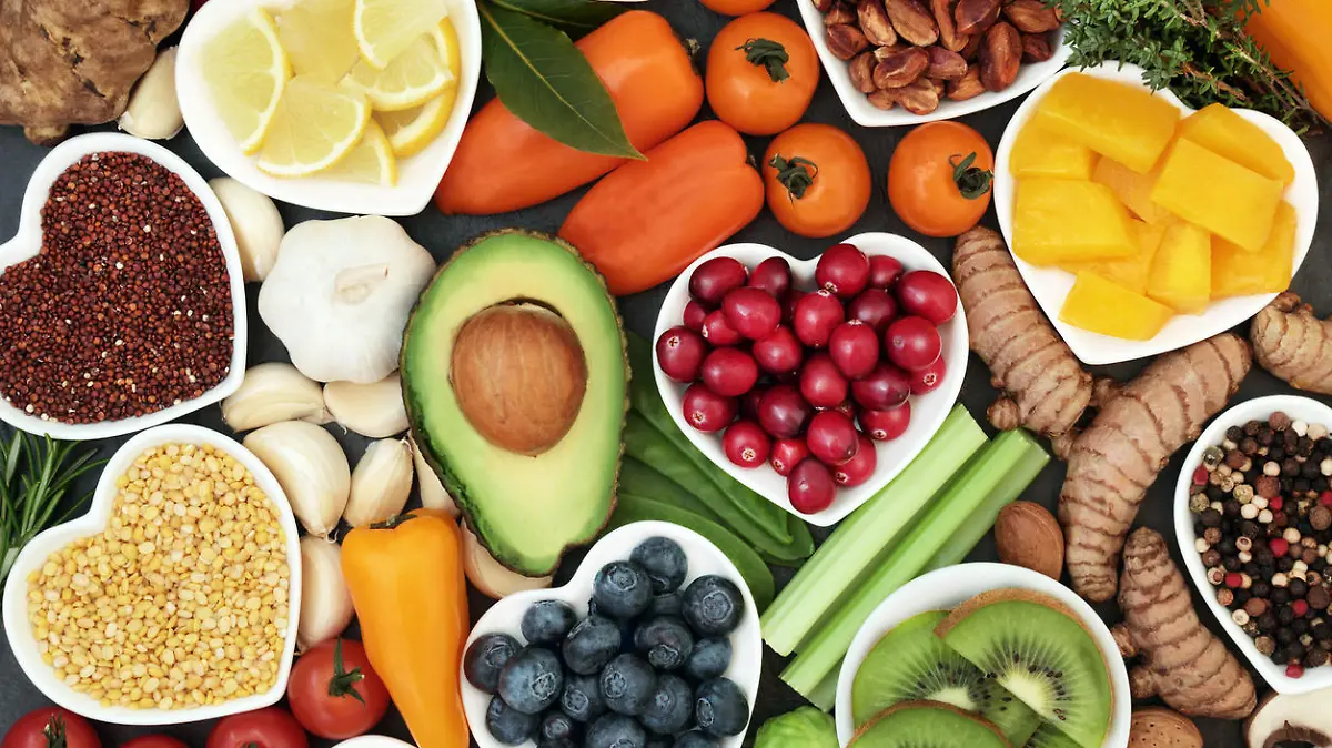 Health food for fitness concept with fresh fruit, vegetables, pulses, herbs, spices, nuts, grains and pulses. High in anthocyanins, antioxidants,smart carbohydrates, omega 3 fatty acids, minerals and vitamins.