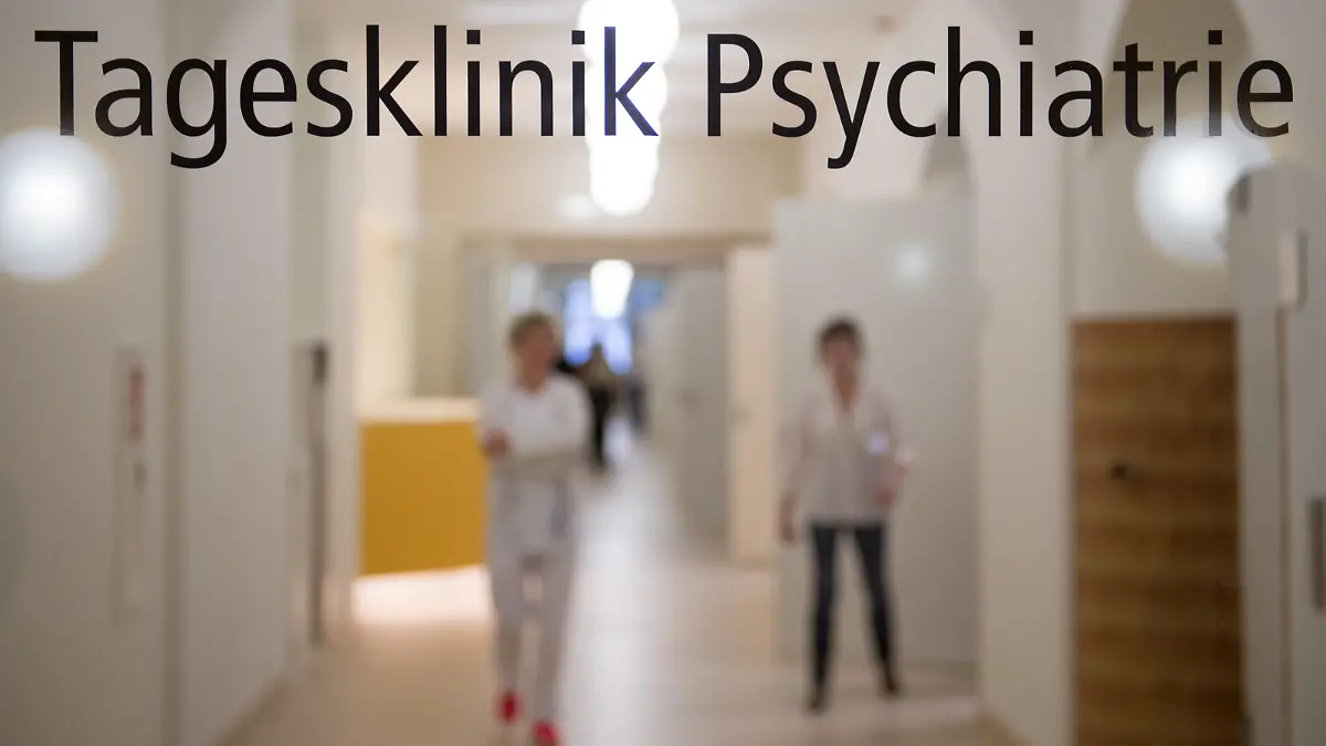 Mitarbeiterinnen des Wald-Klinikums Gera stehen am 23.01.2015 in Gera (Thüringen) im sanierten Hauptgebäude hinter einer Glastür mit der Aufschrift "Tagesklinik Psychiatrie". Das fast 100 Jahre alte, denkmalgeschützte Haus wurde für rund zehn Millionen Euro saniert. Foto: Sebastian Kahnert | Verwendung weltweit