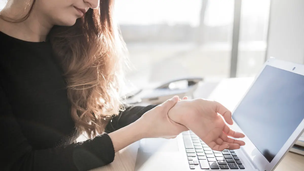 Frau mit Sehnenscheidenentzündung am Computer