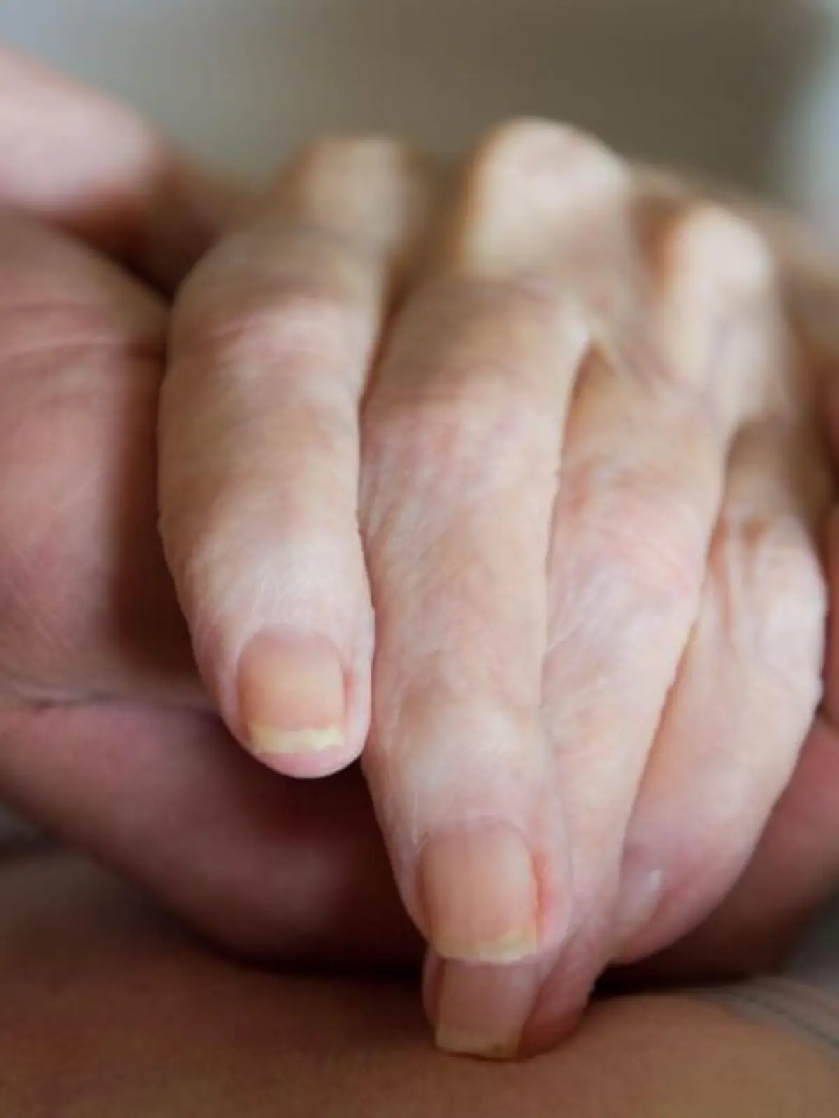 Ein Pfleger hält die Hand einer alten Frau