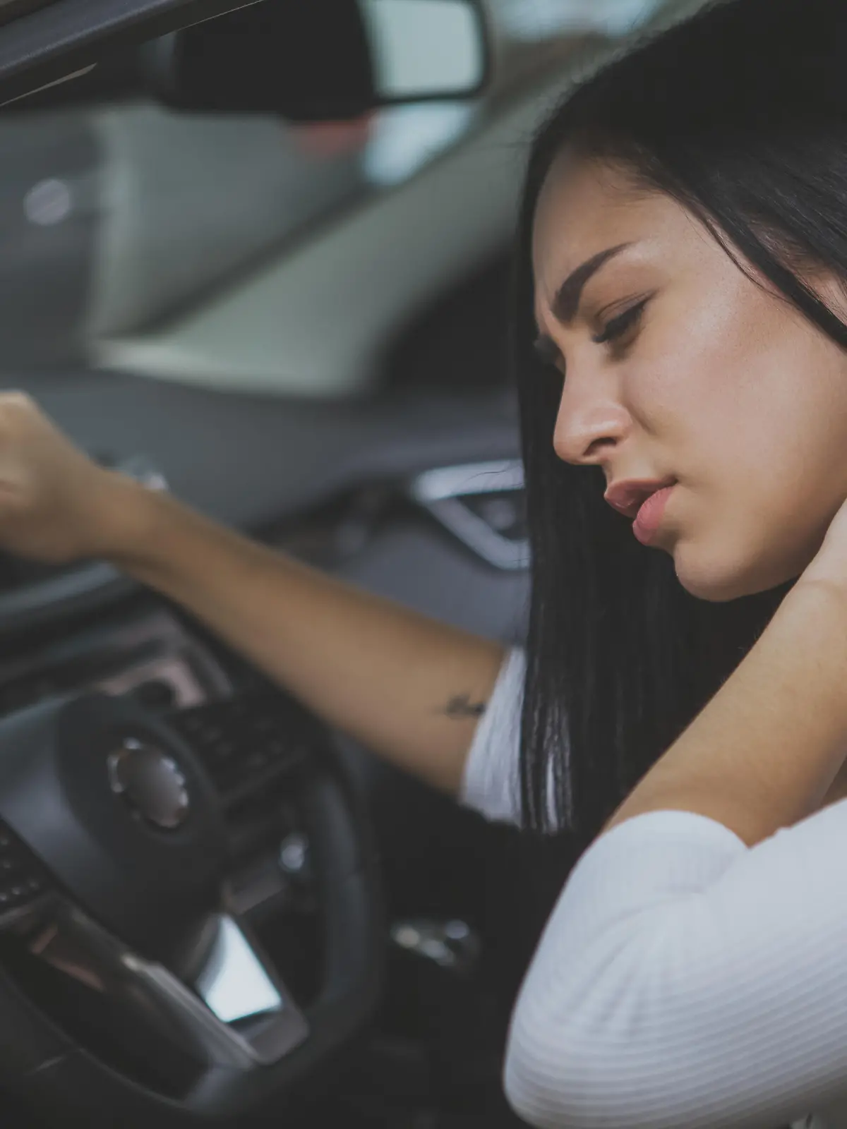 Junge Frau mit Schleudertrauma in ihrem Auto