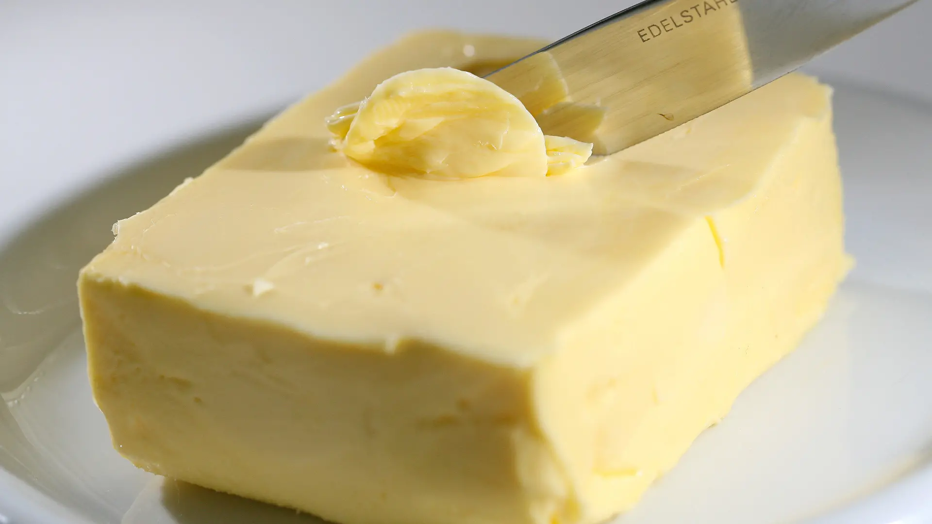 ARCHIV - Mit einem Messer wird Butter abgestrichen, aufgenommen in Düsseldorf (Archivfoto vom 09.07.2008). Die Dänen müssen für gesundheitsschädliches Fett in ihren Lebensmitteln tiefer in die Tasche greifen. Wie geplant ist zum Wochenende eine neue Steuer für gesättigte Fettsäuren von 16 Kronen (2,16 Euro) pro Kilo in Nahrungsmitteln in Kraft getreten. Foto: David Ebener dpa +++(c) dpa - Bildfunk+++