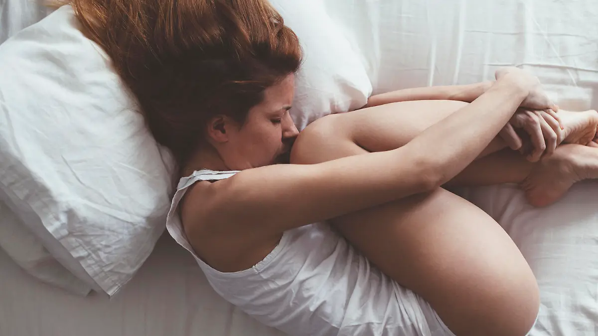 Young woman lying down in fetus position