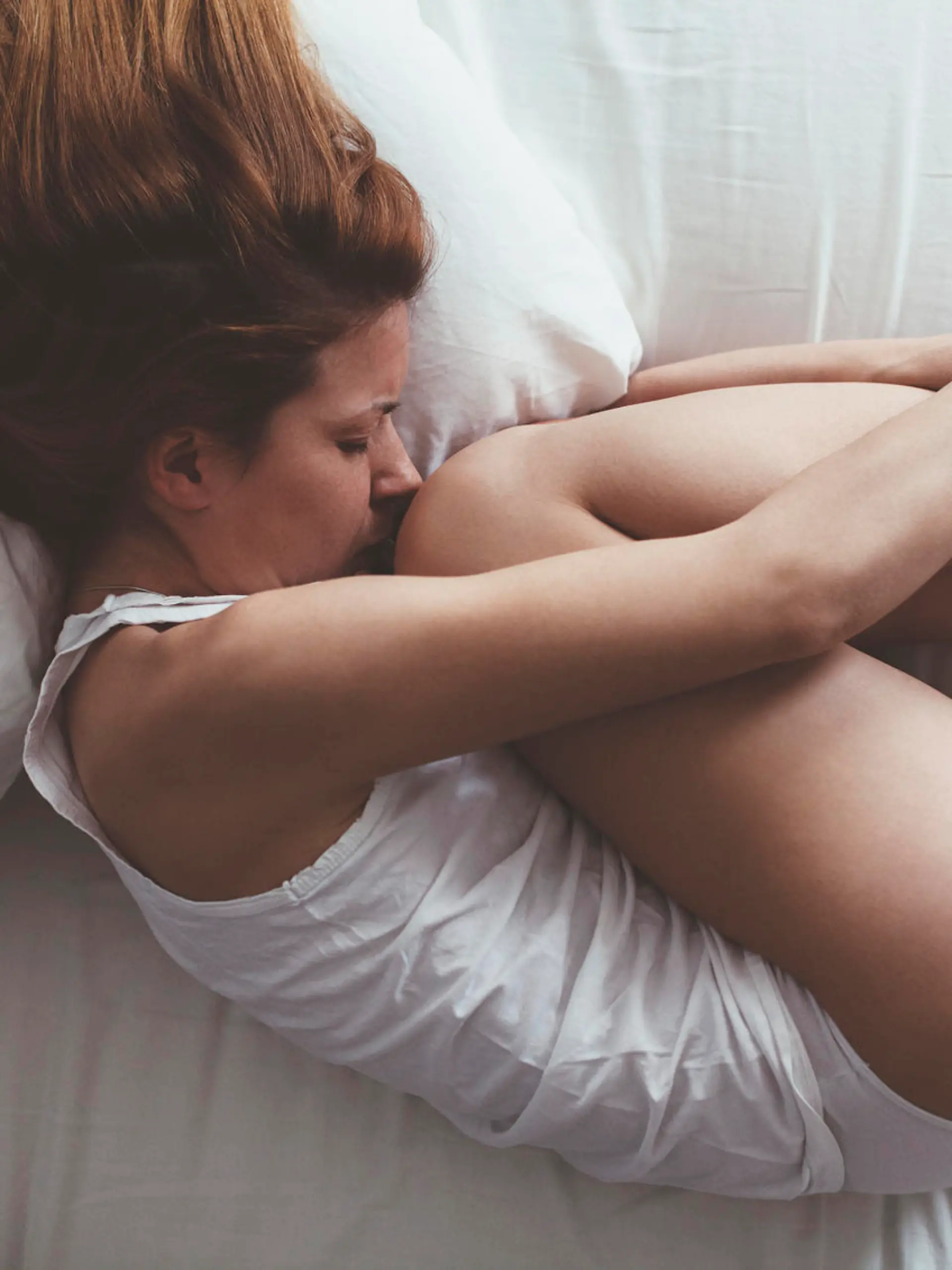 Young woman lying down in fetus position