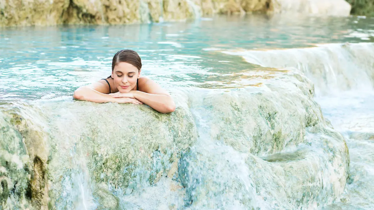 Junge Frau genießt Schwefelbad in Thermalquelle in Saturnia in Italien.
