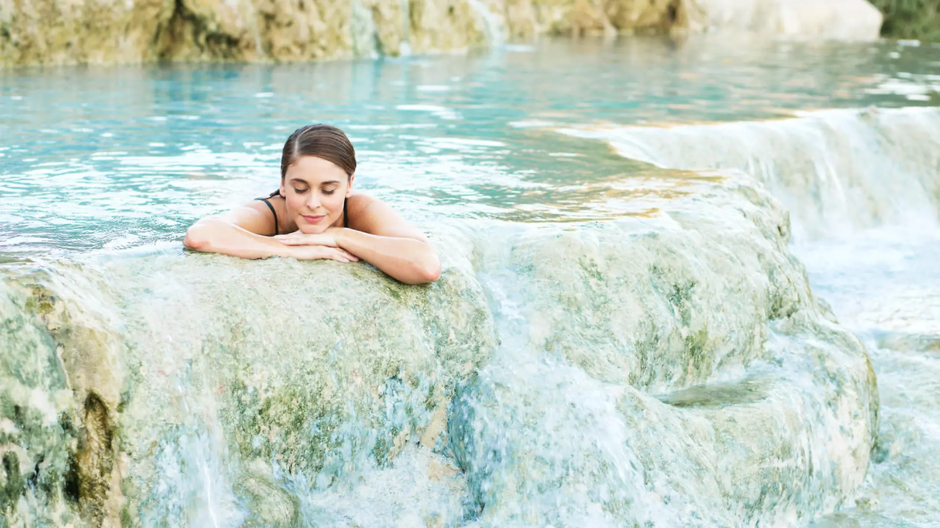 Junge Frau genießt Schwefelbad in Thermalquelle in Saturnia in Italien.