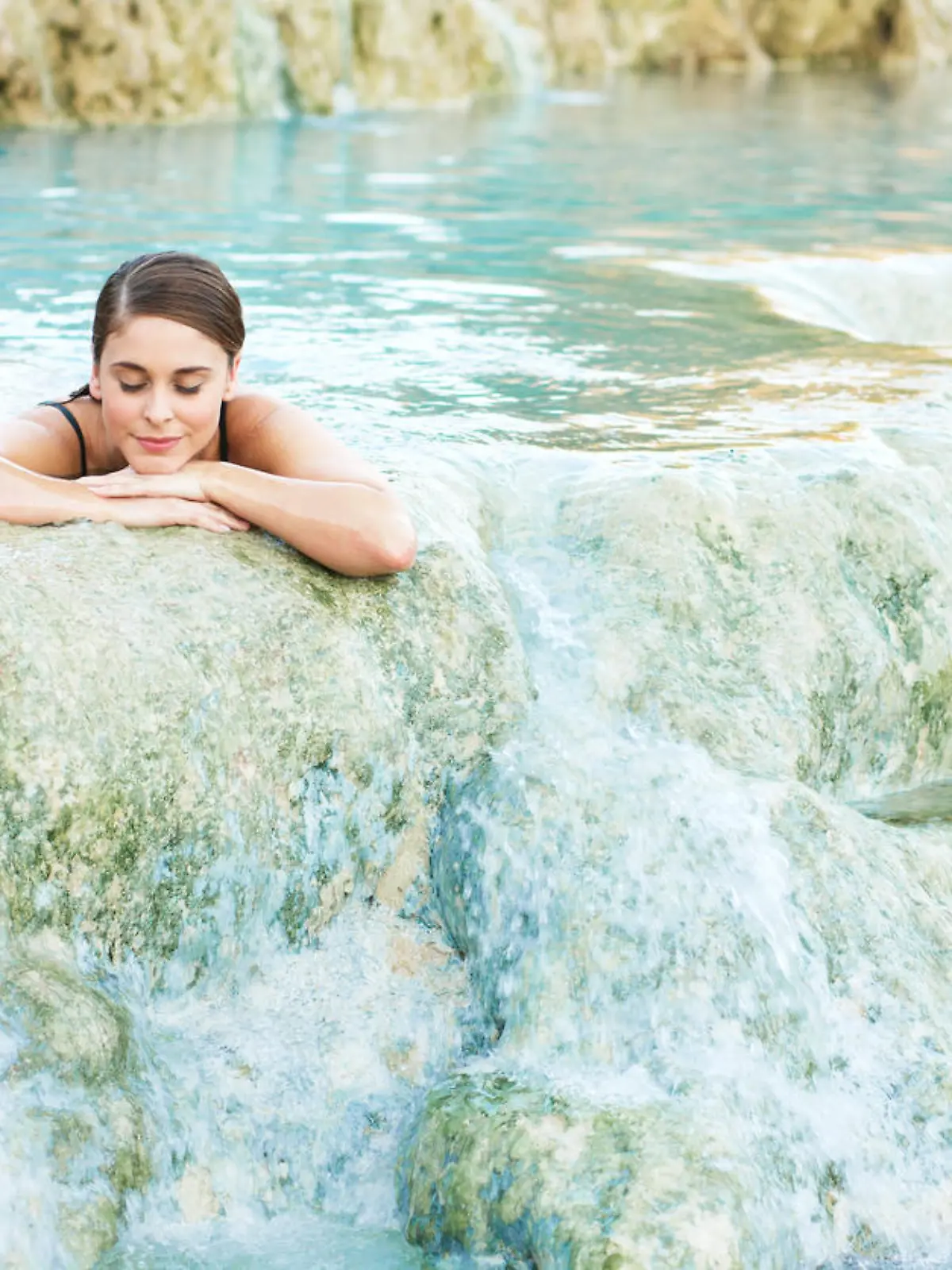 Junge Frau genießt Schwefelbad in Thermalquelle in Saturnia in Italien.