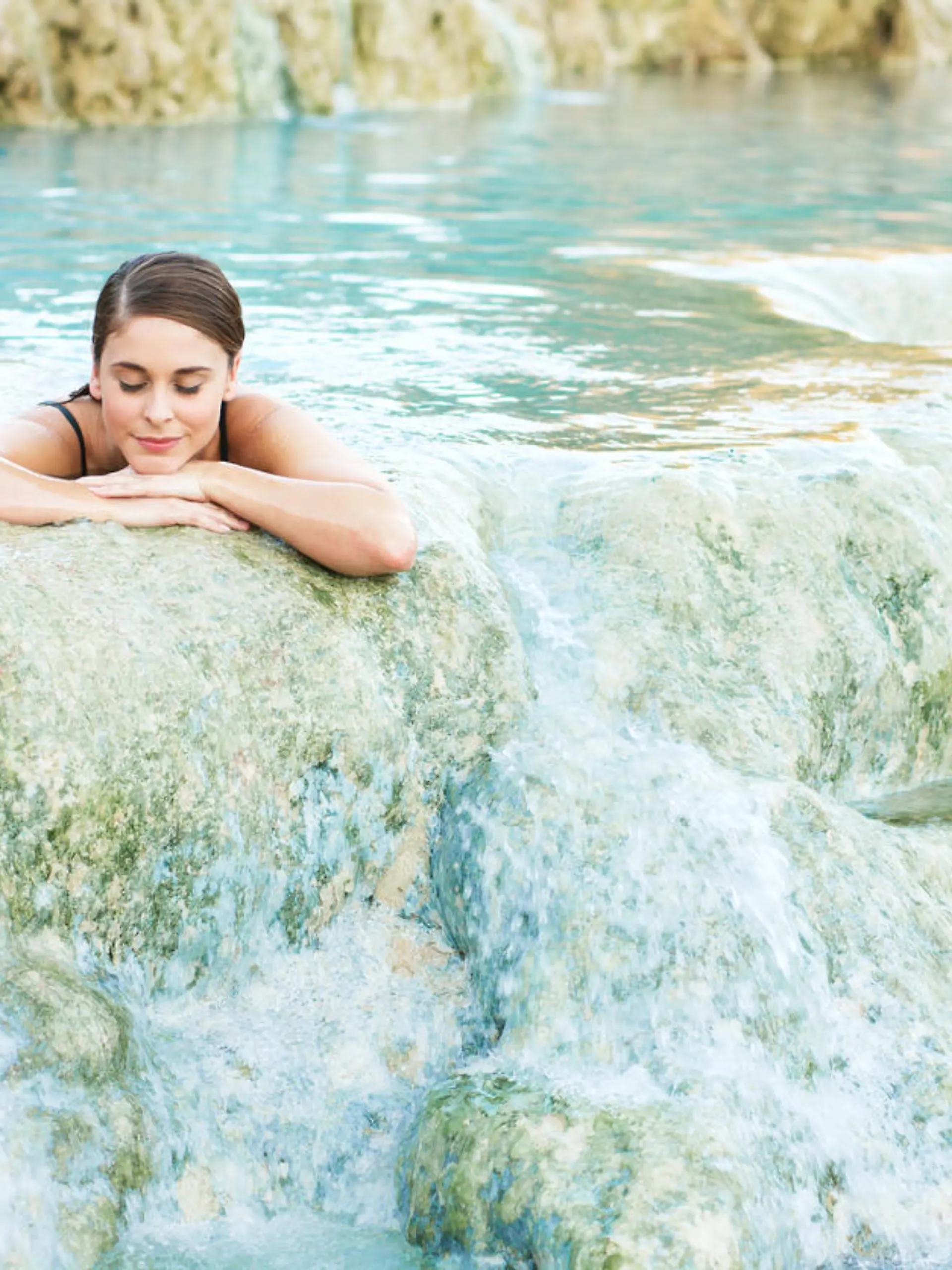 Junge Frau genießt Schwefelbad in Thermalquelle in Saturnia in Italien.