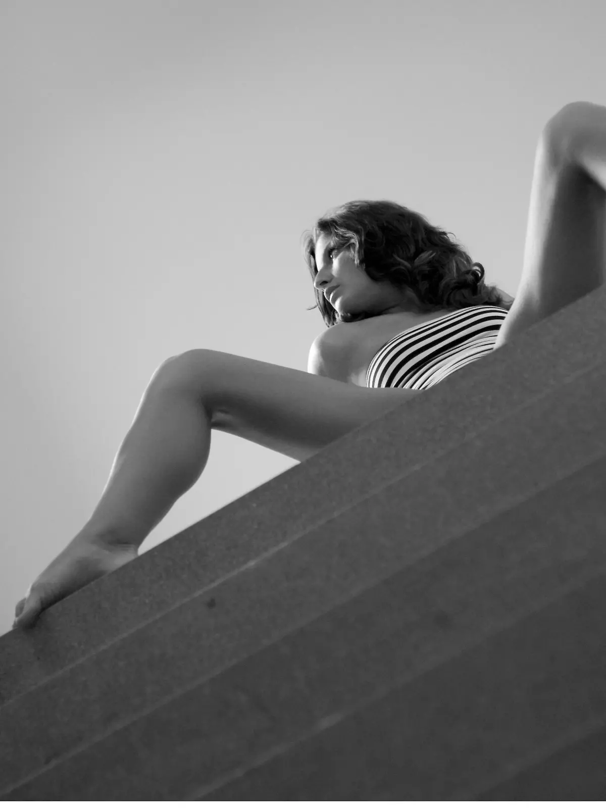 schoene Frau mit langen braunen Haaren in schwarz-weiss gestreifter Unterwaesche, posiert auf einer Treppe | sexy woman with long brown hair, in black and white fasciated lingerie, posing on stairs