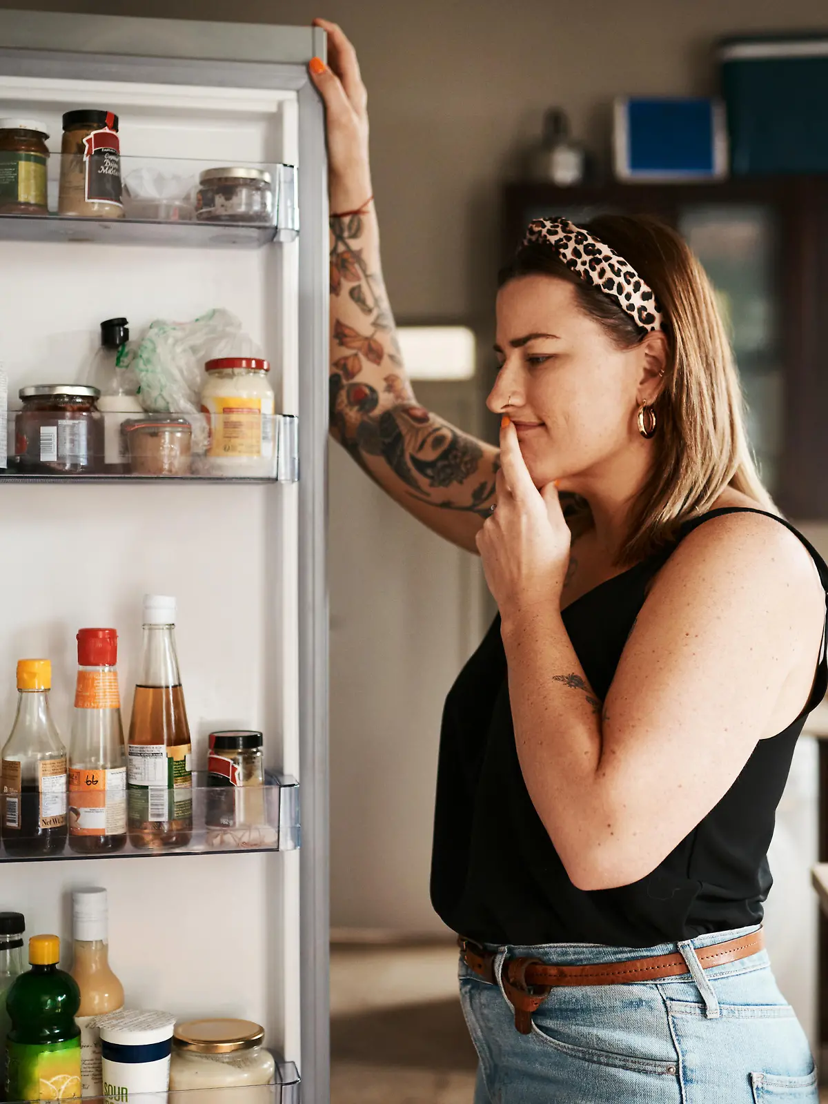 Shot of a young woman searching inside a refrigerator at home