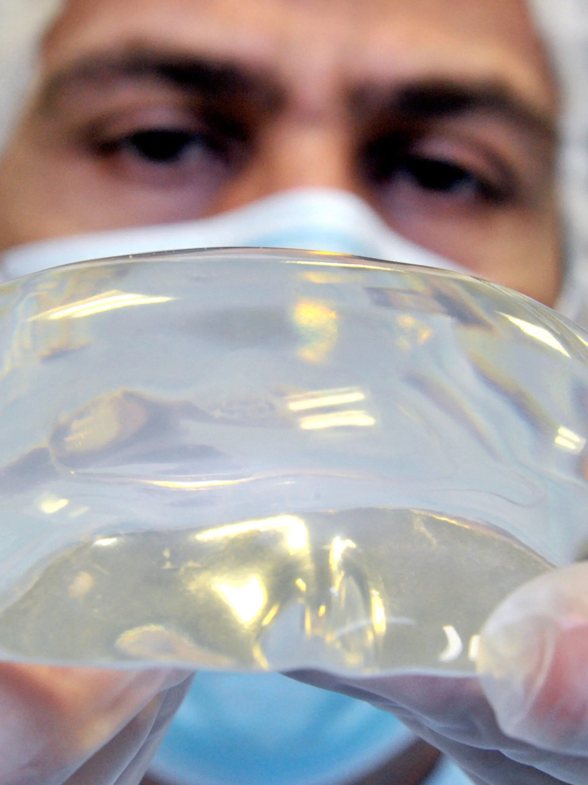 Mit einer optischen Sichtkontrolle nimmt ein Mitarbeiter der Firma Polytech Health and Aesthetics GmbH im hessischen Dieburg am Freitag (06.01.2012) ein Silikonimplantat für den Gluteus Maximus (Grosser Gesässmuskel) in Augenschein. Die Firma ist der einzige deutsche Hersteller von medizinischen Brustimplantaten und Spezialimplantaten. Foto: Boris Roessler dpa/lhe (zu dpa-Korr "Hersteller: Keine vorschnelle Entfernung von Billig-Implantaten" vom 06.01.2012)  +++(c) dpa - Bildfunk+++