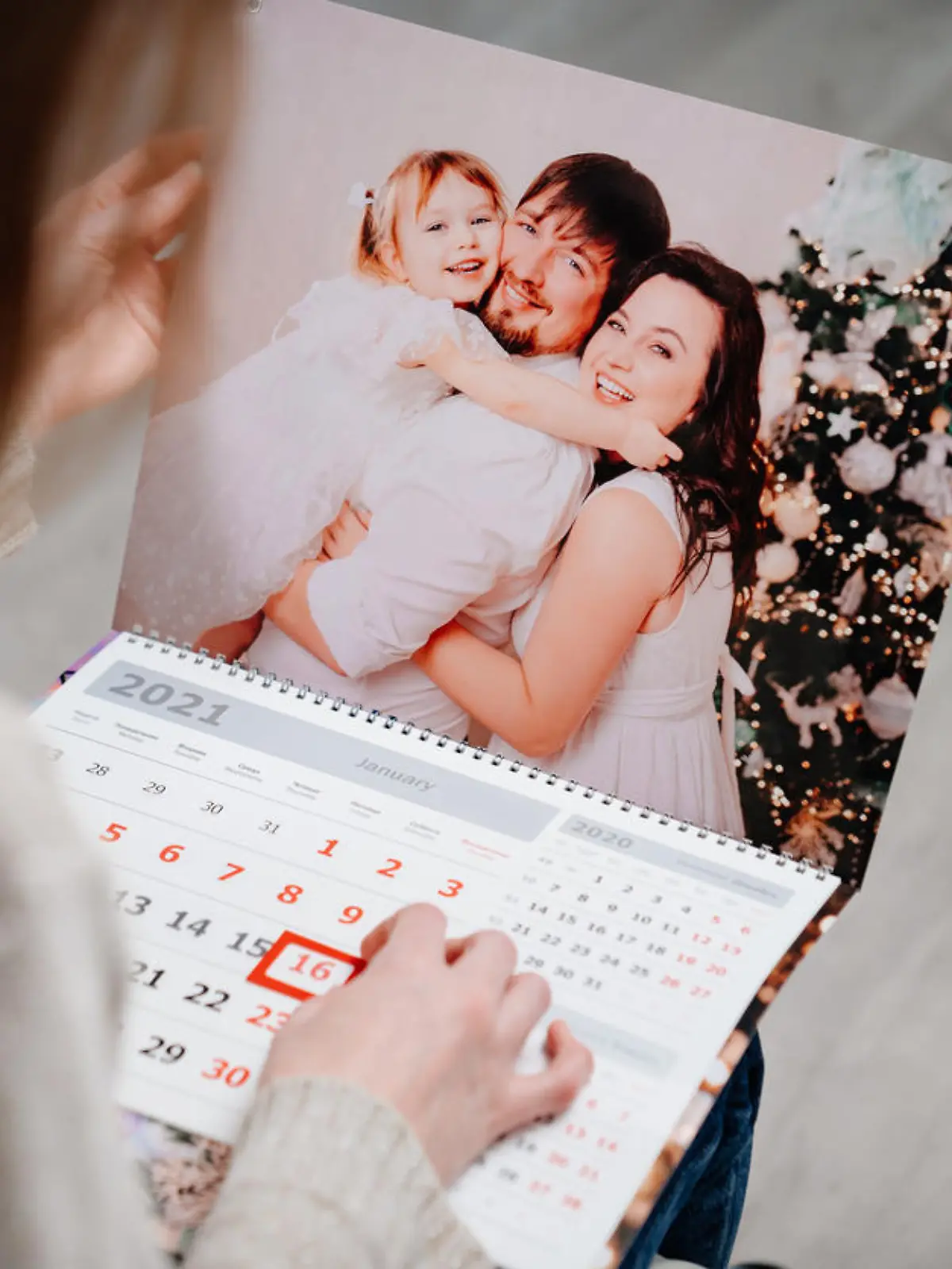 A woman looks at a calendar with a family photo. A useful gift with your photos. Souvenir. additional photographer's service.