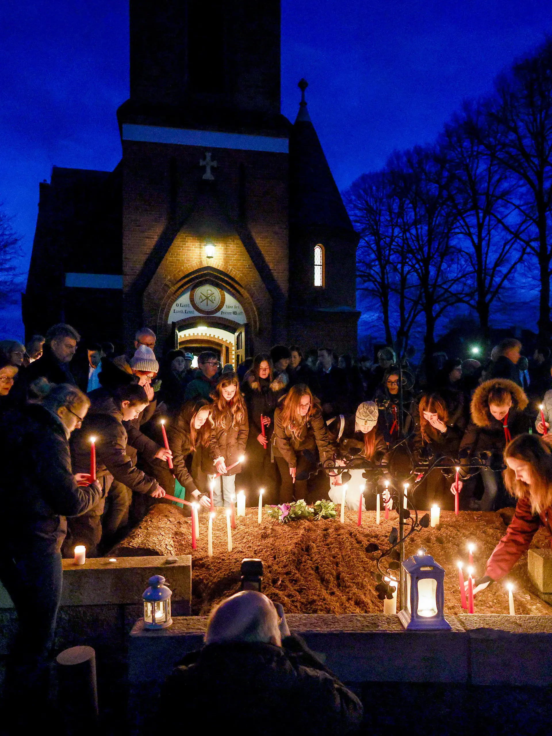 dpatopbilder - 27.01.2023, Schleswig-Holstein, Brokstedt: Teilnehmer der Andacht der Evangelisch-Lutherischen Kirchengemeinde Brokstedt für die Opfer des Messerangriffs stellen nach dem Gottesdienst Kerzen vor der Kirche auf. Bei der Messerattacke in dem Regionalzug waren am Mittwoch eine 17-Jährige und ein 19-Jähriger getötet worden, fünf Menschen wurden verletzt. Foto: Axel Heimken/dpa +++ dpa-Bildfunk +++