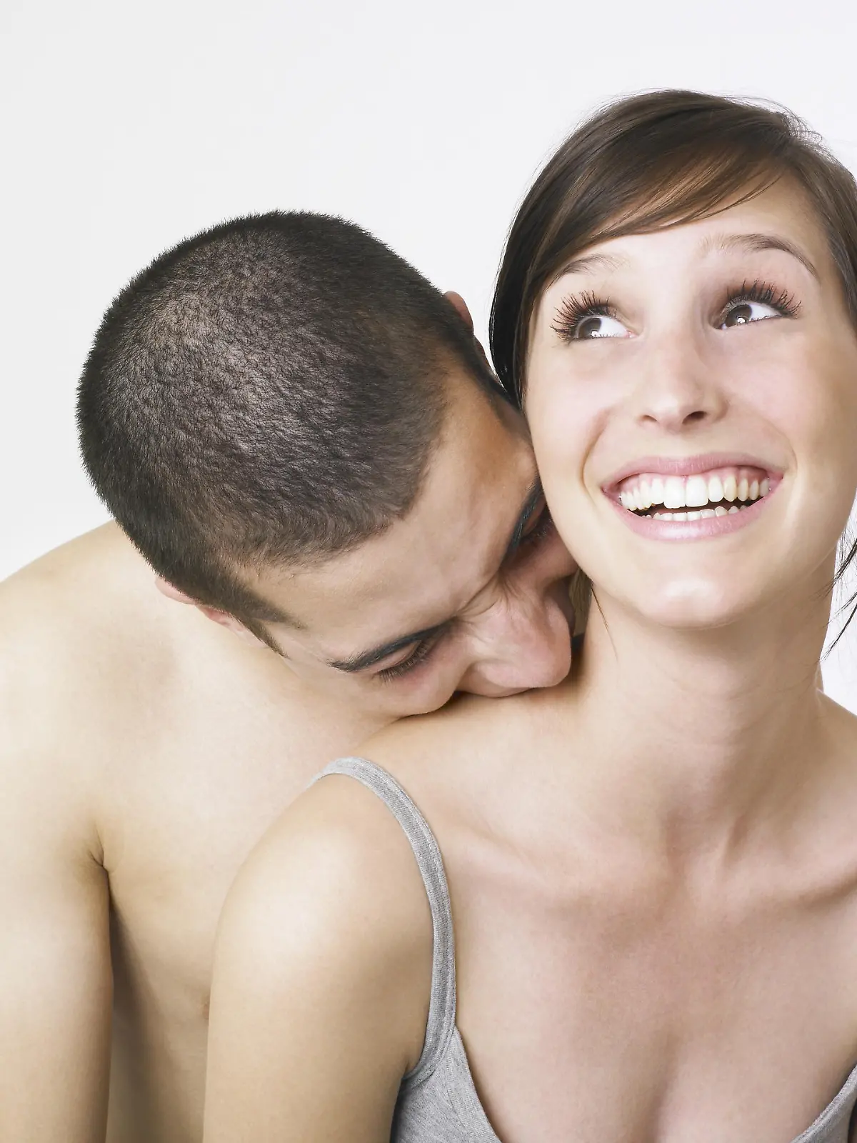 Young couple playing with man biting woman and she shouting in delight. 