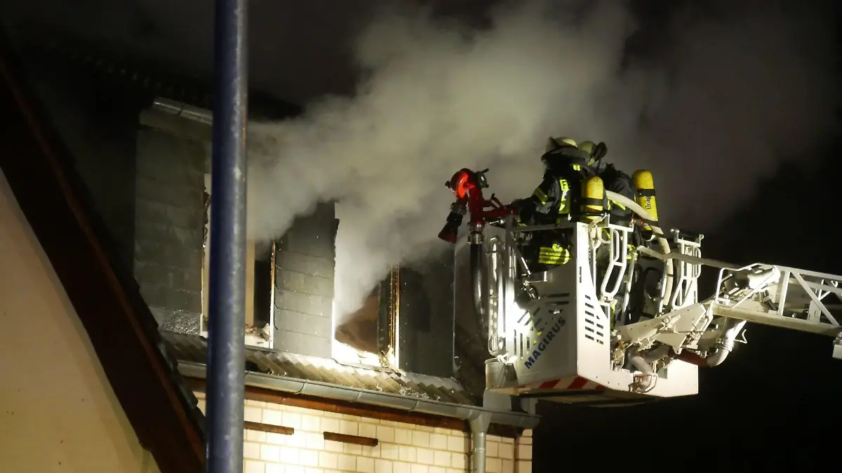 Immer wieder schlagen die Flammen aus dem Gebäude und erschweren die Löscharbeiten.