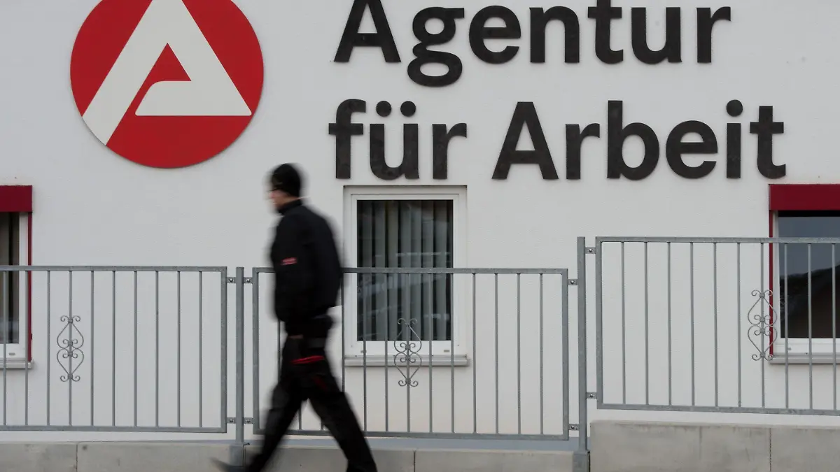 ARCHIV - Ein Passant geht am 04.02.2015 in Schmalkalden (Thüringen) an dem Logo der Agentur für Arbeit vorbei. Foto: Sebastian Kahnert/dpa (zu dpa «Jobcenter verhängen mehr Sanktionen gegen Hartz-IV-Empfänger» vom 17.04.2016) +++(c) dpa - Bildfunk+++