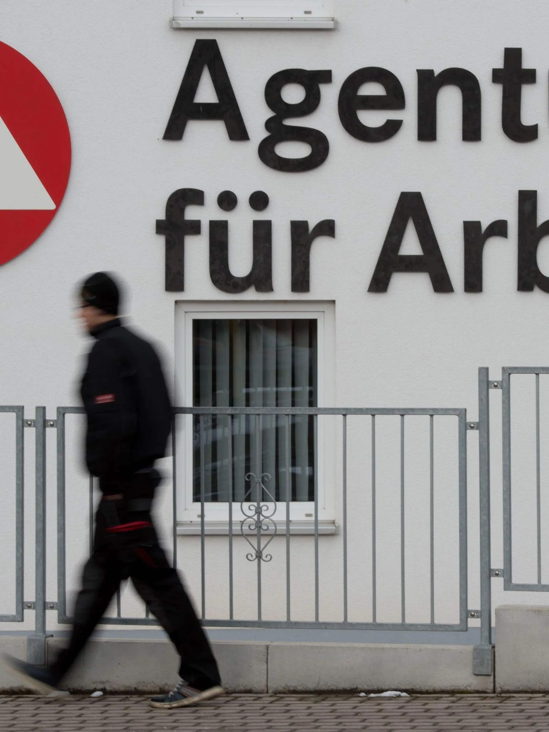 ARCHIV - Ein Passant geht am 04.02.2015 in Schmalkalden (Thüringen) an dem Logo der Agentur für Arbeit vorbei. Foto: Sebastian Kahnert/dpa (zu dpa «Jobcenter verhängen mehr Sanktionen gegen Hartz-IV-Empfänger» vom 17.04.2016) +++(c) dpa - Bildfunk+++