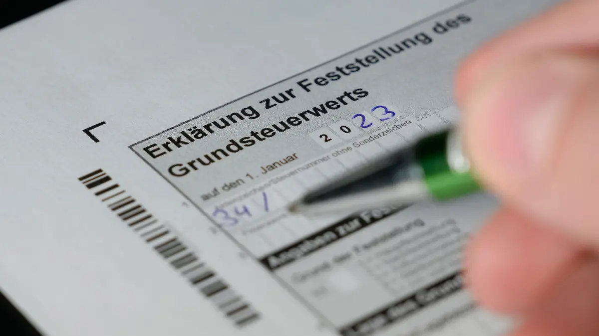Symbolfoto und Themenbild beim Ausfuellen des Bogen zur Ermittlung, Erklaerung und Abgabe des Grundsteuerwertes mit Blick auf die Grundsteuerreform. Grundsteuerabgabe an das Finanzamt