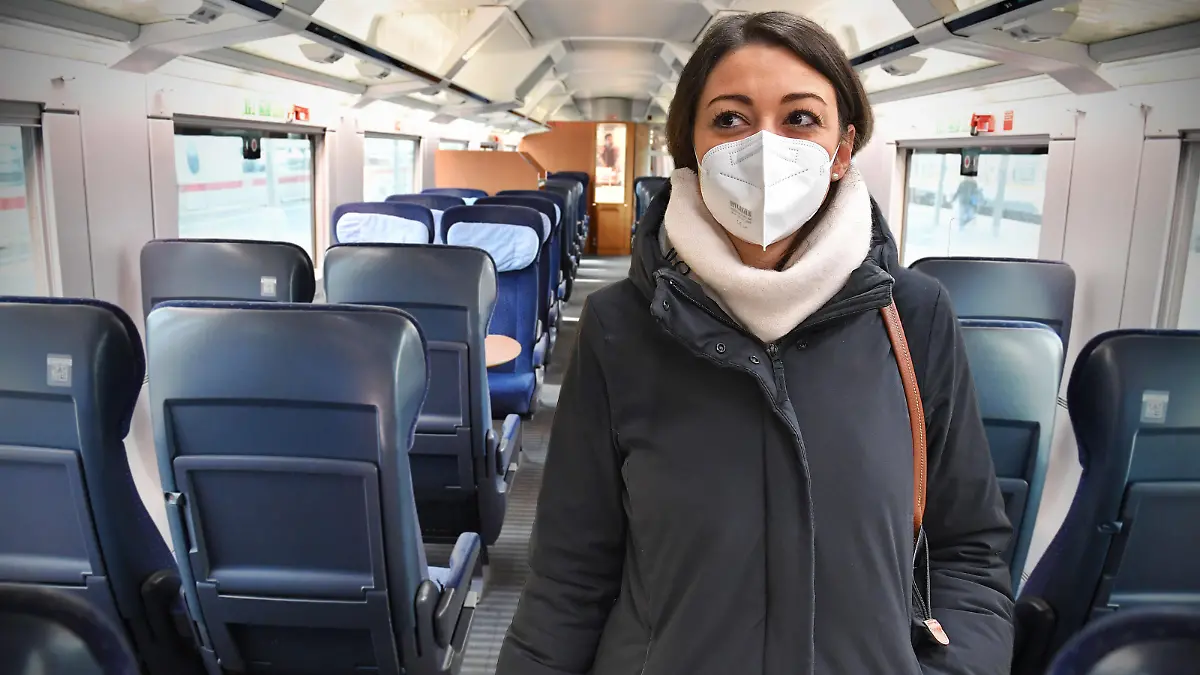 FOTOMONTAGE: Vom 2.Februar 2023 an entfaellt die Maskenpflicht im Fernverkehr. ARECHIVFOTO; Deutsche Bahn prueft Einfuehrung einer FFP2 Maskenpflicht. Junge Frau mit FFP2 Maske, Oeffentliches Leben in Zeiten der Coronavirus Pandemie.Blick in einen leeren Grossraumwagen,Waggon eines ICE Zuges der DB.Alle Plaetze ,Sitze sind unbesetzt und voellig leer. Ausgangsbeschraenkungen,Kontaktsperre. ?