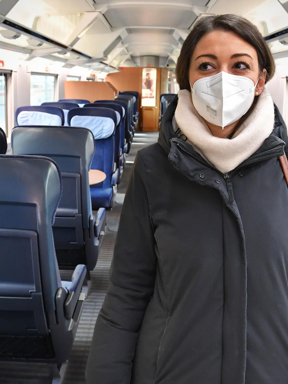 FOTOMONTAGE: Vom 2.Februar 2023 an entfaellt die Maskenpflicht im Fernverkehr. ARECHIVFOTO; Deutsche Bahn prueft Einfuehrung einer FFP2 Maskenpflicht. Junge Frau mit FFP2 Maske, Oeffentliches Leben in Zeiten der Coronavirus Pandemie.Blick in einen leeren Grossraumwagen,Waggon eines ICE Zuges der DB.Alle Plaetze ,Sitze sind unbesetzt und voellig leer. Ausgangsbeschraenkungen,Kontaktsperre. ?
