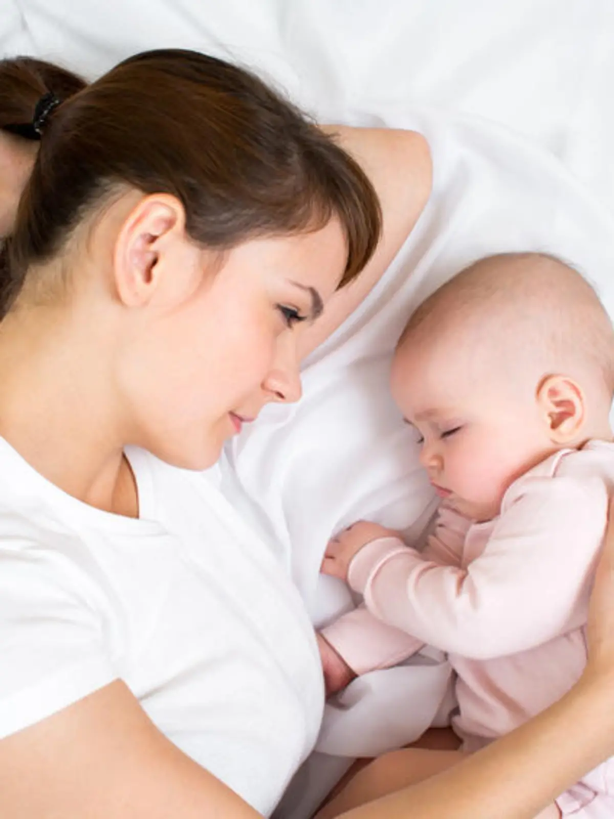 Young mother looking at her sleeping baby