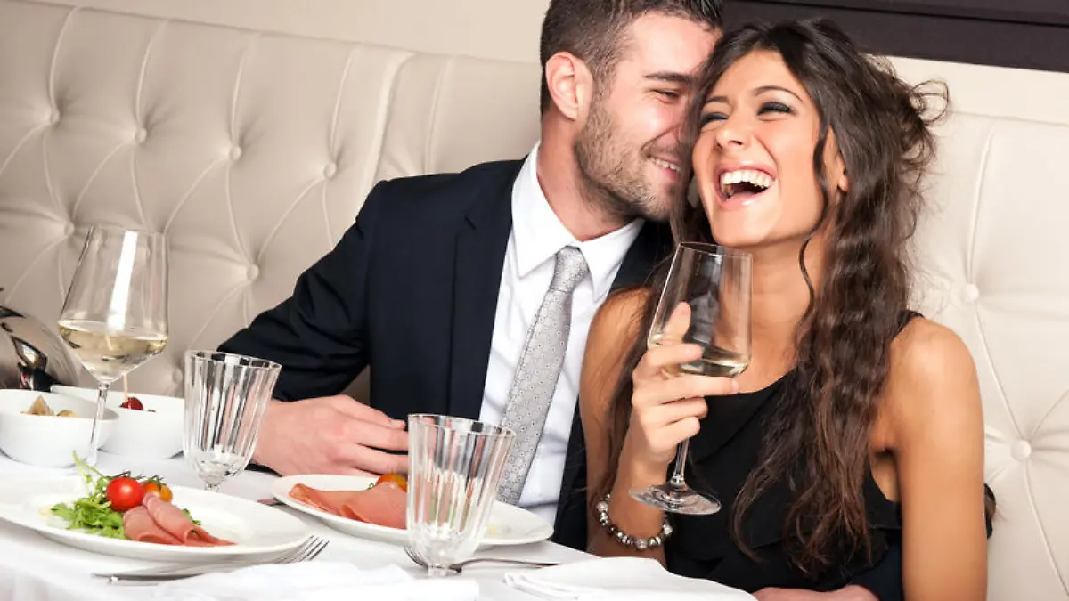 Attractive elegant young couple drinking a cocktail at the restaurant.