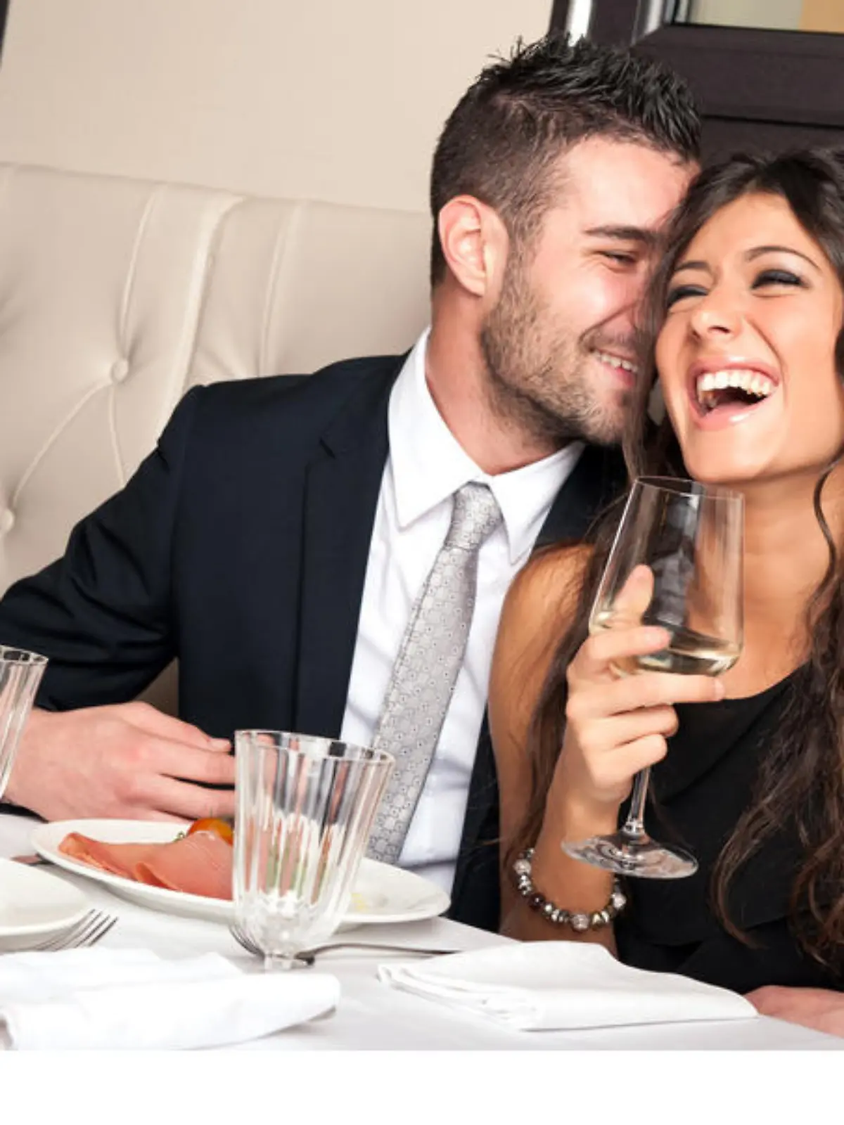 Attractive elegant young couple drinking a cocktail at the restaurant.