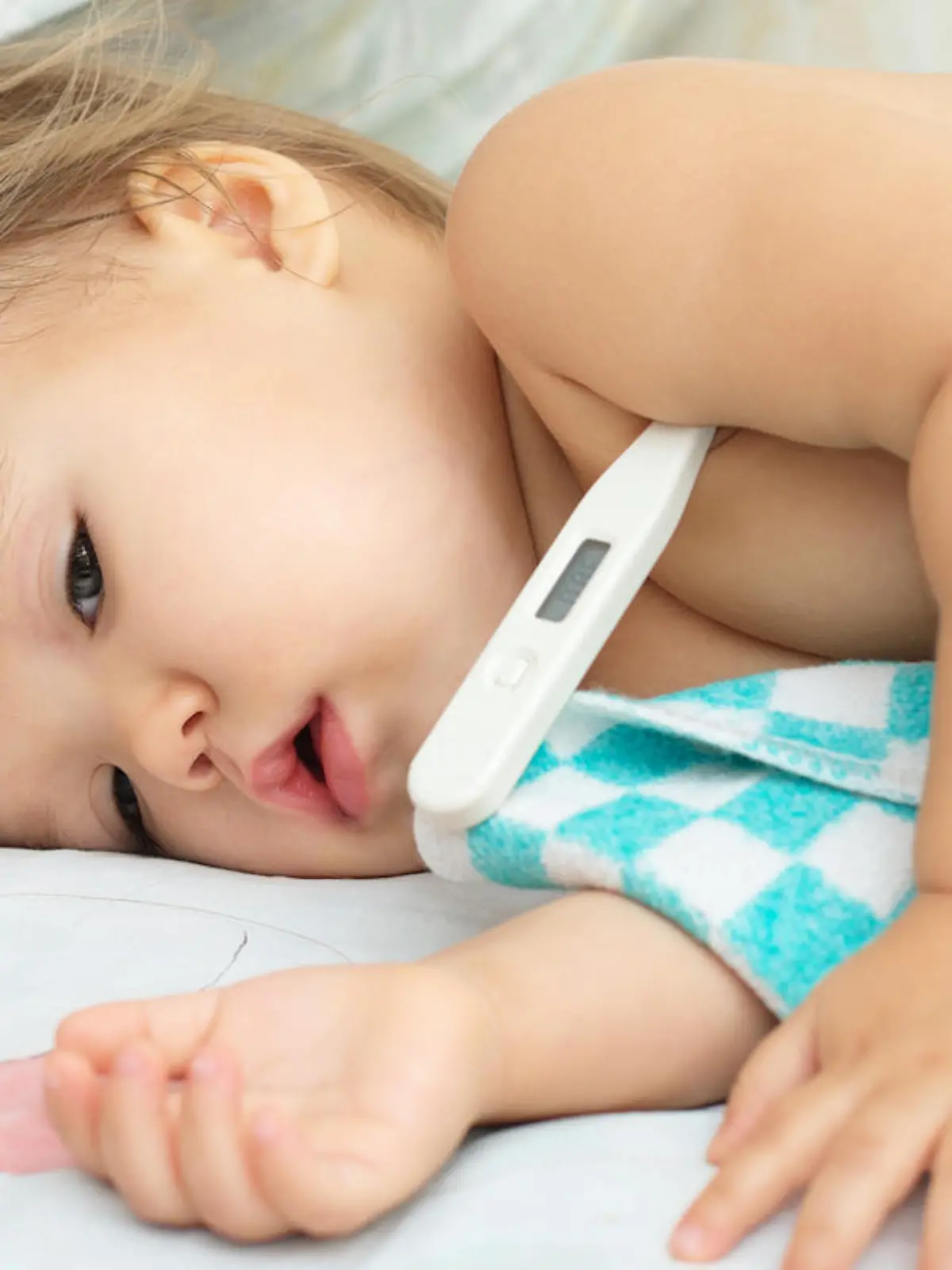 Kleinkind mit Thermometer unterm Arm