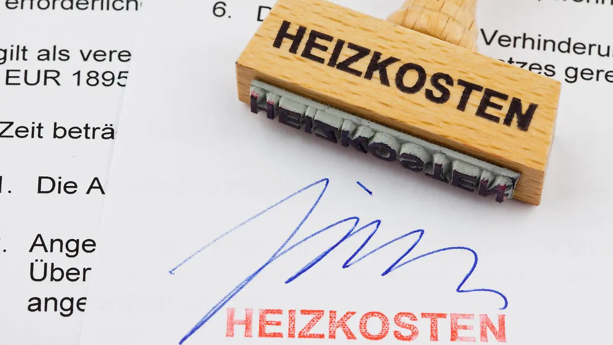 Ein Stempel aus Holz liegt auf einem Dokument. Deutsche Aufschrift: Heizkosten McPBBO McPBBO