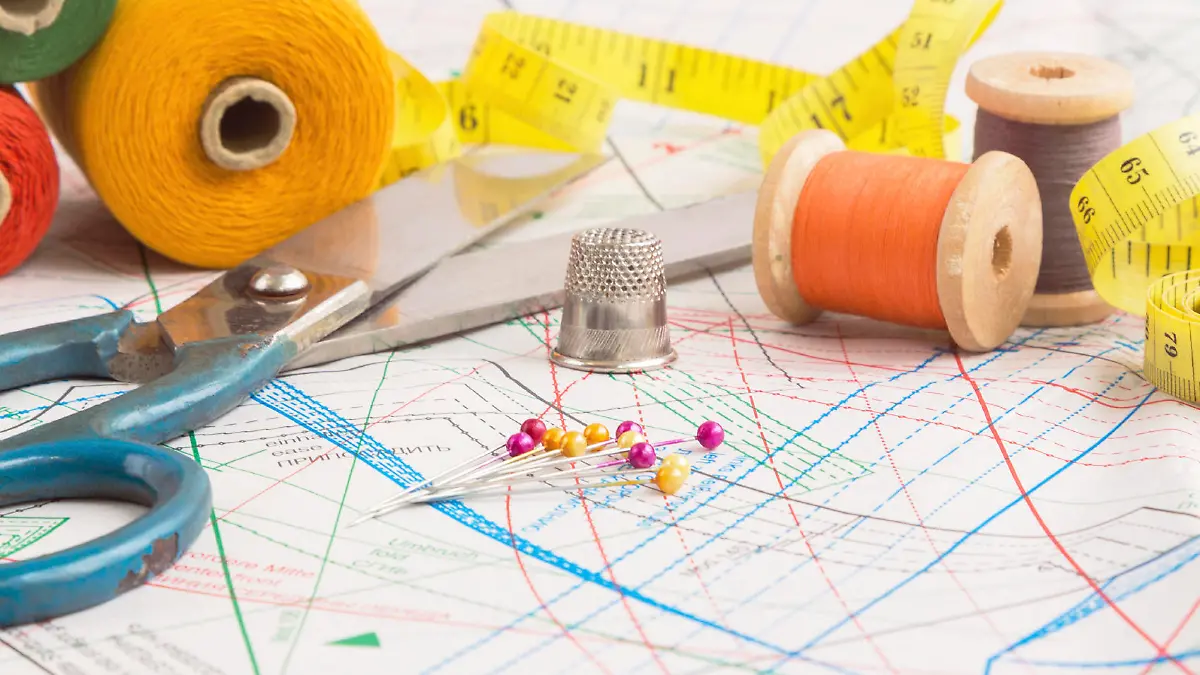 Sewing items background with old scissors, thread spools and tape measure