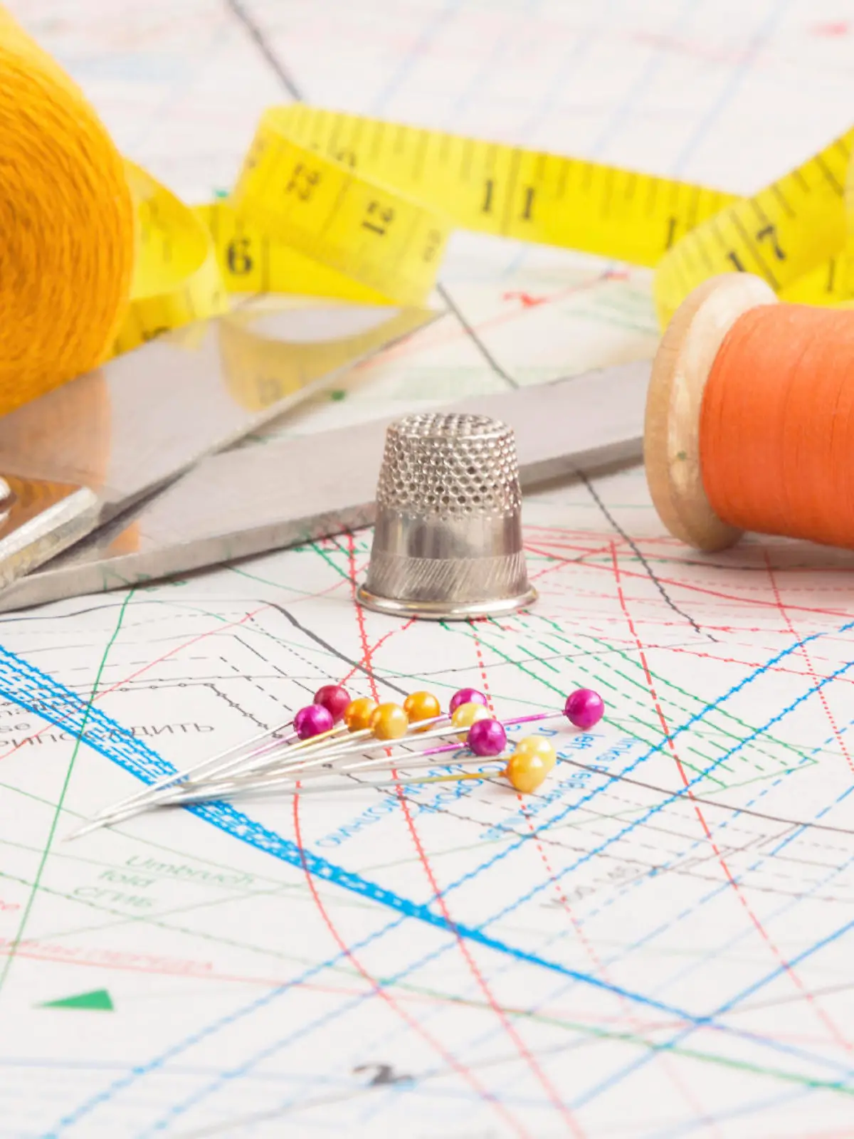 Sewing items background with old scissors, thread spools and tape measure