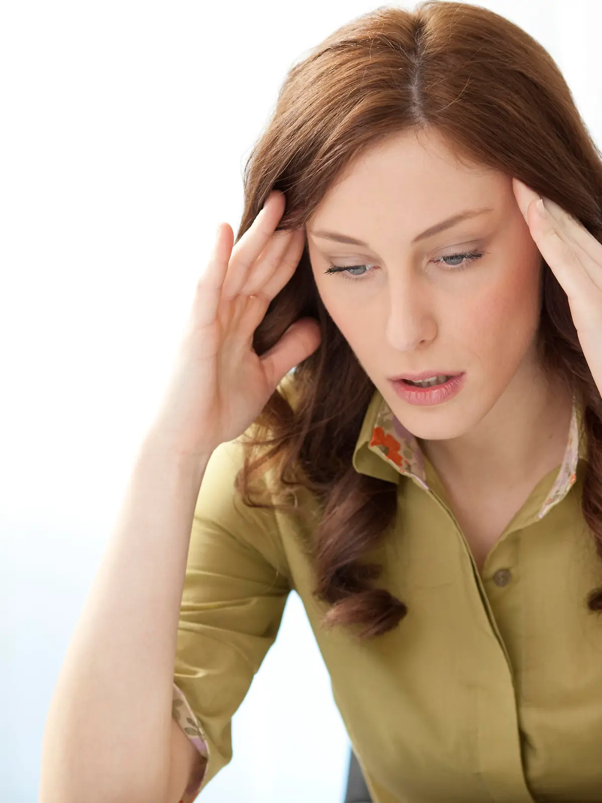 "Young Businesswoman Having Headache in the office, doing massage of the head and sitting at the desk."