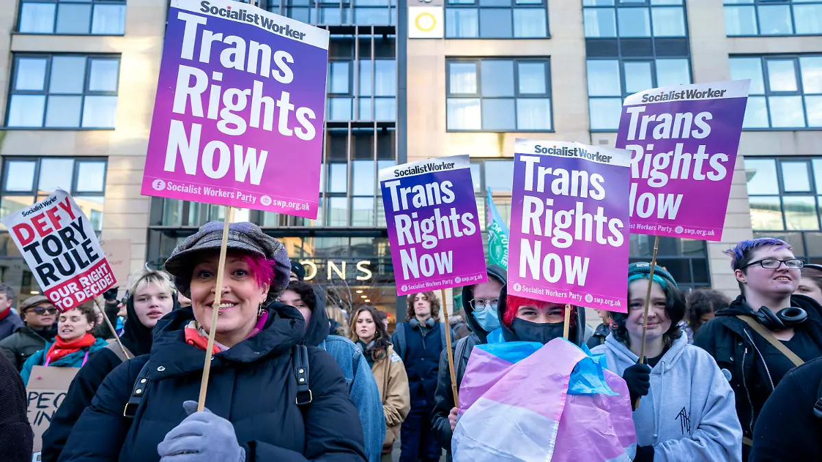 People take part in a demonstration for trans rights outside the UK Government Office at Queen Elizabeth House in Edinburgh, Scotland, Thursday Jan. 19, 2023. The demonstration is taking place after the UK Government moved to block laws reforming the gender recognition process in Scotland from gaining Royal Assent. (Jane Barlow/PA via AP)