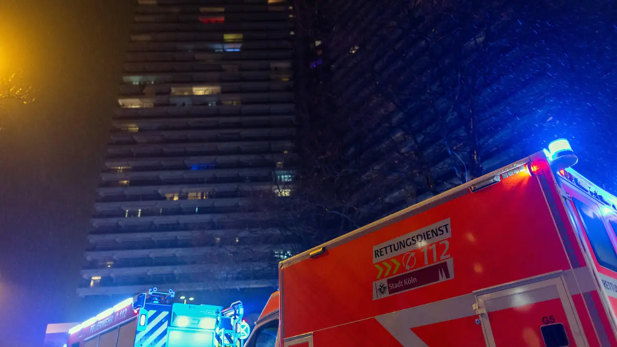 PRODUKTION - 26.01.2023, Nordrhein-Westfalen, Köln: Einsatzkräfte der Feuerwehr stehen vor dem Uni-Center. Im Uni-Center Köln, das als eines der größten Wohnhäuser in Europa gilt, ist am Donnerstagabend ein Feuer ausgebrochen. Mehrere Anrufer hätten Rauch gemeldet, dieser breite sich über alle 42 Stockwerke aus, sagte ein Feuerwehrsprecher. 50 bis 60 Bewohner seien evakuiert worden. Foto: Rolf Vennenbernd/dpa +++ dpa-Bildfunk +++