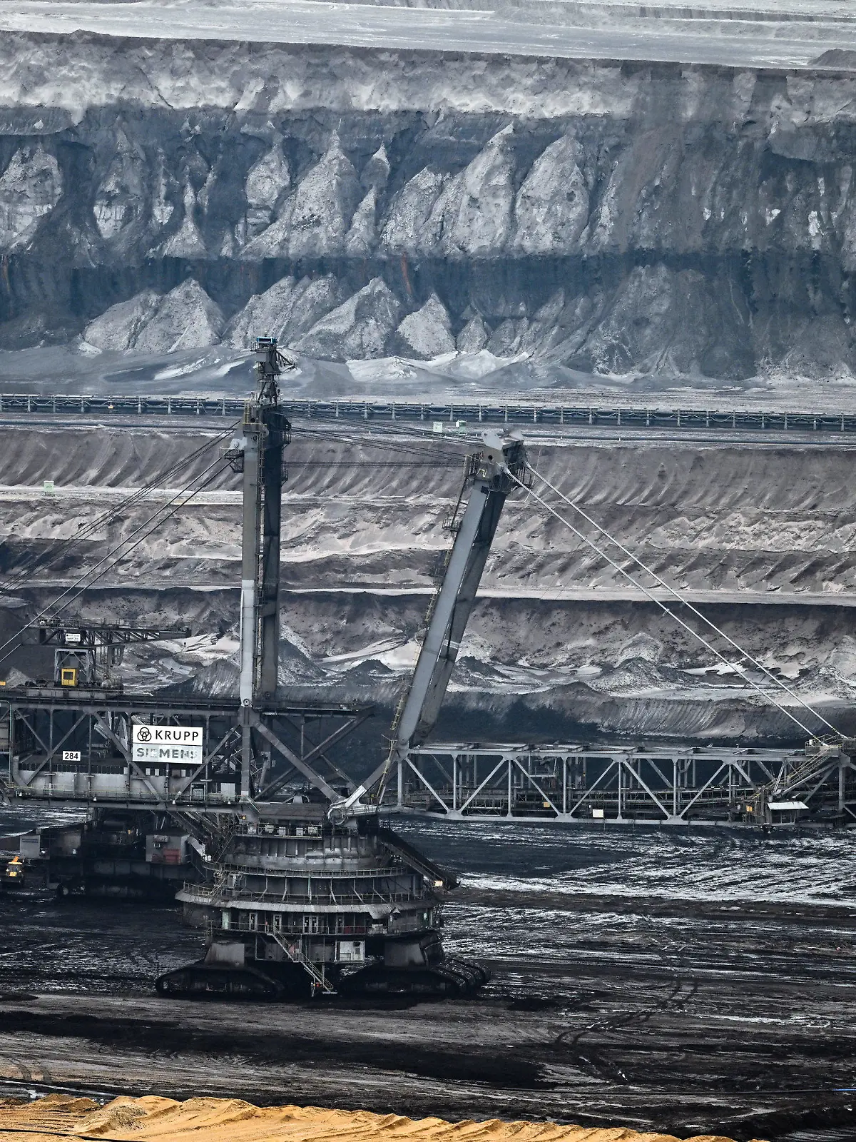 PRODUKTION - 23.01.2023, Nordrhein-Westfalen, Erkelenz: Bergbaumaschinen arbeiten im Tagebau Garzweiler. Die Stadt Erkelenz stellt eine geplante Bürgerbeteiligung «Zukunftsvision Tagebaurand» vor. Zum Stadtgebiet am Tagebau Garzweiler gehören fünf, bereits weitgehend leerstehende Dörfer, die wegen des vorzeitigen Braunkohleausstiegs erhalten bleiben. Foto: Federico Gambarini/dpa +++ dpa-Bildfunk +++