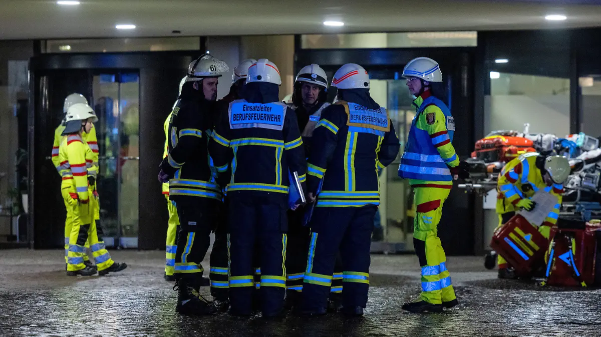 PRODUKTION - 26.01.2023, Nordrhein-Westfalen, Köln: Einsatzkräfte der Feuerwehr stehen vor dem Uni-Center. Im Uni-Center Köln, das als eines der größten Wohnhäuser in Europa gilt, ist am Donnerstagabend ein Feuer ausgebrochen. Mehrere Anrufer hätten Rauch gemeldet, dieser breite sich über alle 42 Stockwerke aus, sagte ein Feuerwehrsprecher. 50 bis 60 Bewohner seien evakuiert worden. Foto: Rolf Vennenbernd/dpa +++ dpa-Bildfunk +++