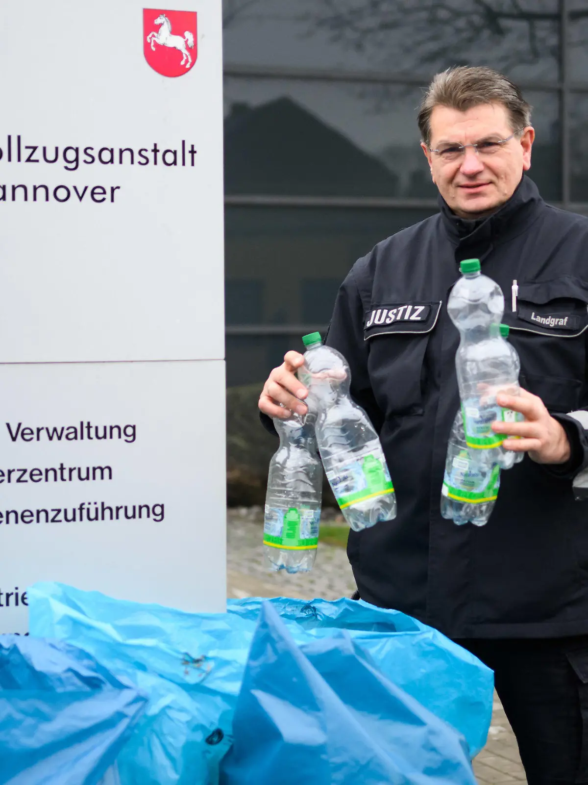 23.01.2023, Niedersachsen, Hannover: Peter Landgraf, Pressesprecher JVA Hannover, steht mit gesammelten Pfandflaschen in der Justizvollzugsanstalt Hannover. Häftlinge der JVA Hannover sammeln Pfandflaschen für den guten Zweck: Im Jahr 2022 kam so eine Spendensumme von über 700 Euro zusammen. (zu dpa: «Häftlinge der JVA Hannover sammeln Pfandflaschen für kranke Kinder») Foto: Julian Stratenschulte/dpa +++ dpa-Bildfunk +++