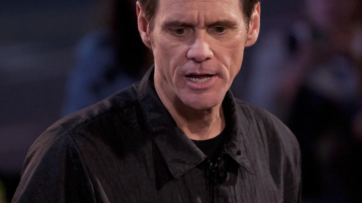Nov. 13, 2014 - Hollywood, California, USA - Canadian born actor and comedian Jim Carrey performed a 'Dumb & Dumber 2' bowl cut on a male volunteer Thursday evening in a skit set-up outside the El Capitan Theater in Hollywood. In addition, Carrey did a complete buzz cut on a female volunteer leaving only the small outline of his carefully crafted hand on the top of her head. Carrey set-up a gag with the male volunteer where it appeared he cut off his ear, holding the 'cut off' ear up and pretending to eat it before throwing it off camera. As Carrey cut the hair of the female volunteer, he placed a large portion just under his nose as if it were his mustache