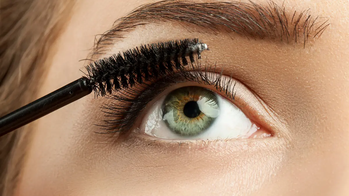 Close-up of make-up green eye with long lashes with black mascara