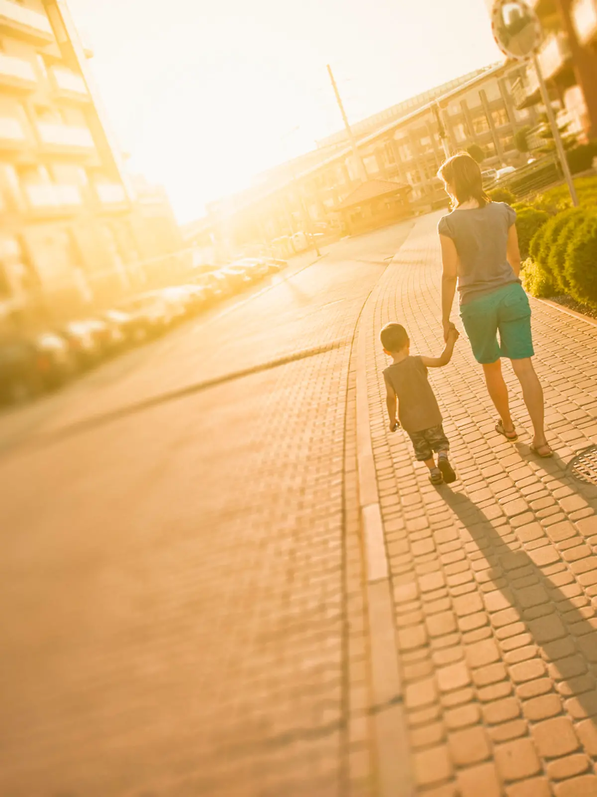 Mother and son walking in urban area.