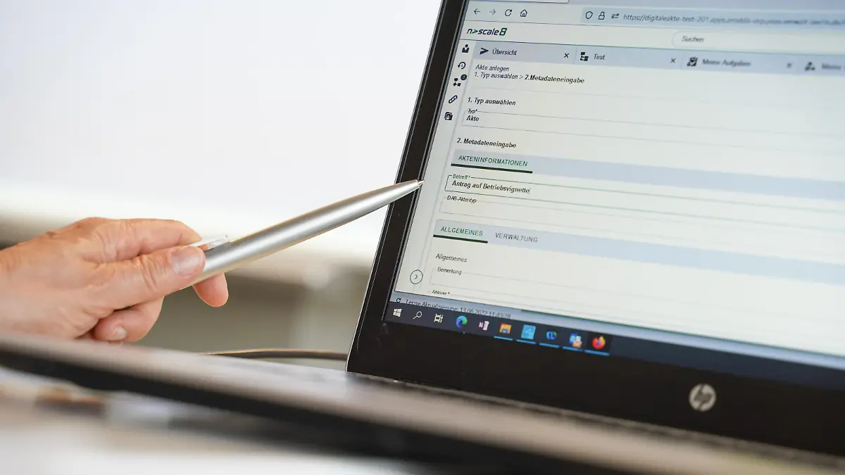 Eine Frauenhand zeigt mit einem Kugelschreiber beim Start der Digitalen Akte im Bezirksamt Mitte auf einen Computer, auf dem eine Eingabemaske zu sehen ist. Das Bezirksamt Mitte ist die erste Behörde, die seit Mitte Mai 2022 die neue Version Digitale Akte zur elektronischen Aktenführung nutzt. Diese soll bis Ende 2024 für rund 70.000 PC-Arbeitsplätze in etwa 80 Behörden flächendeckend bereitgestellt werden. +++ dpa-Bildfunk +++