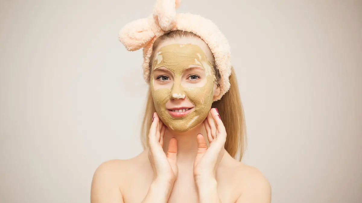 Junge Frau macht Wellness mit Schlamm-Gesichtsmaske